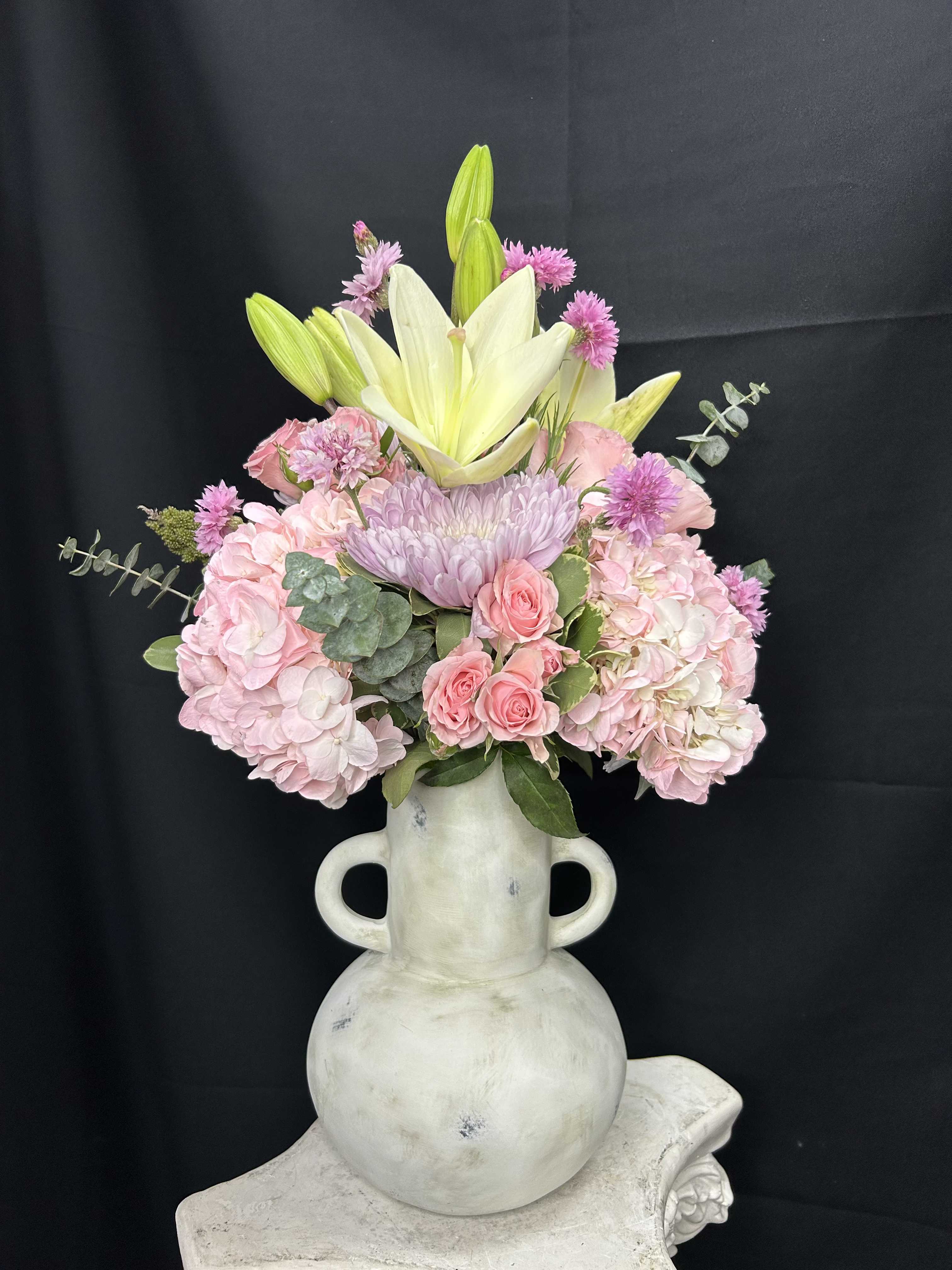 Pink and white floral arrangement in a white vase