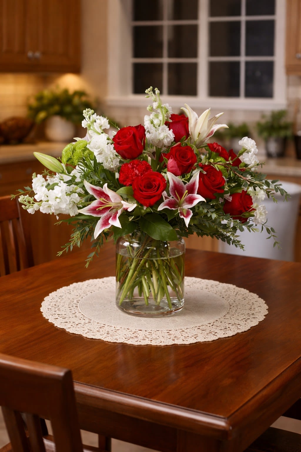 Red roses and white lilies arranged in a clear glass vase