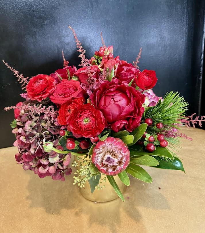 Red floral arrangement in a clear glass vase with pink accents