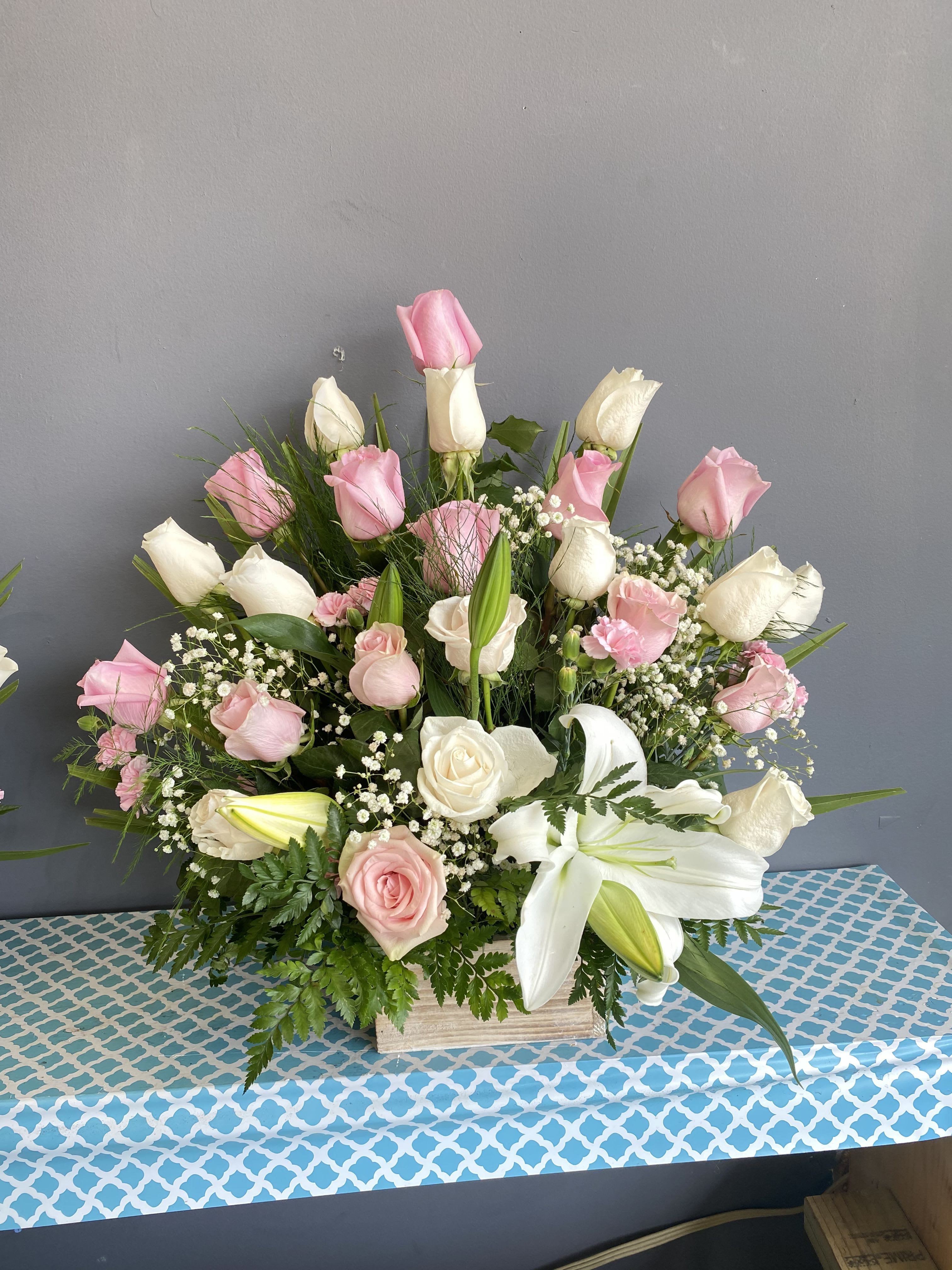 Pink and white roses with lilies in a wooden box arrangement