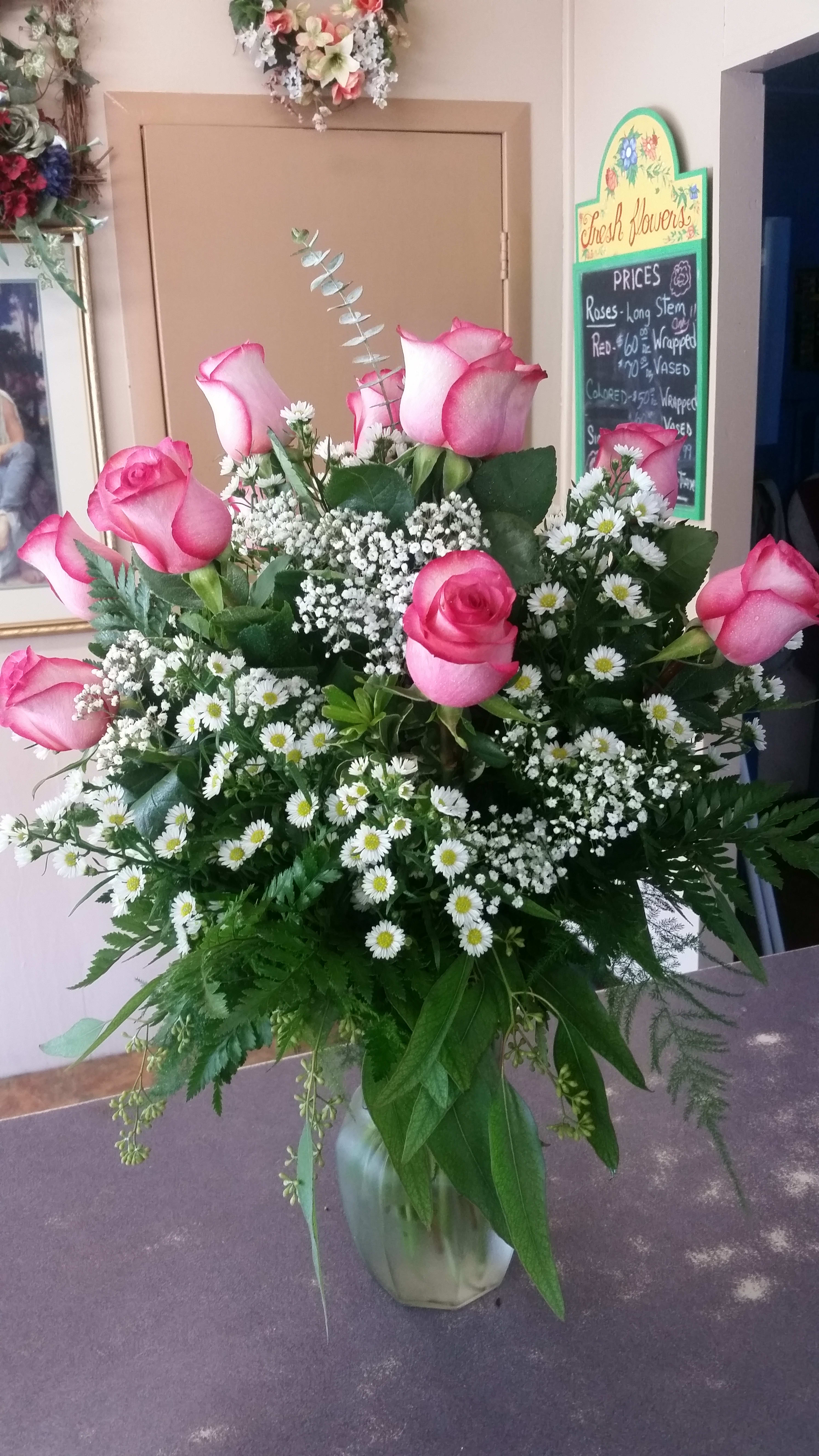 Pink roses and white daisies arranged in a glass vase