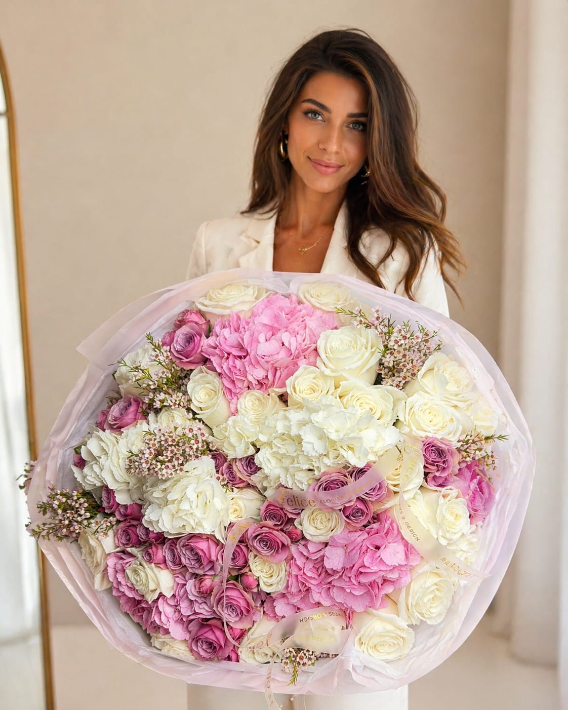 Grand Blush Elegance Bouquet - Lush clusters of blush spray roses and full roses mingle with creamy hydrangeas in a large, rounded hand-tied flower arrangement-perfect as a birthday bouquet, anniversary gift, or a grand congratulations bouquet. The soft pink, white, and purple palette reads romantic and celebratory; the person you send it to will feel truly cherished by its abundant, feminine presence.  This generous bouquet features premium roses, spray roses, hydrangeas, and delicate seasonal accent blooms arranged with textured filler around the edges for a layered, voluminous look. Presented upright as a hand-tied gift, it's finished in soft pink tissue wrap and a decorative ribbon for a polished, ready-to-give presentation. Colors are blush pink, ivory white, and touches of mauve/purple.  Sized and styled to read as a luxury statement piece, it's ideal for marking birthdays, anniversaries, Mother's Day, or any congratulations moment when you want someone to feel seen and celebrated. Handcrafted by Felice Flowers &amp; Design; seasonal substitutions may occur but the overall color palette, size, fullness, and luxe style will remain consistent with the photo.