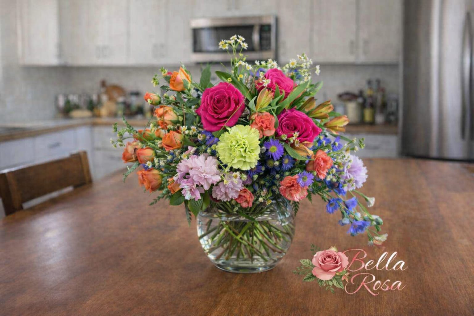 Garden path  - Gorgeous mixed color blooms are combined with greenery to create a scene reminiscent of a stroll down a garden path arranged in a bowl or cube depending on availability. 