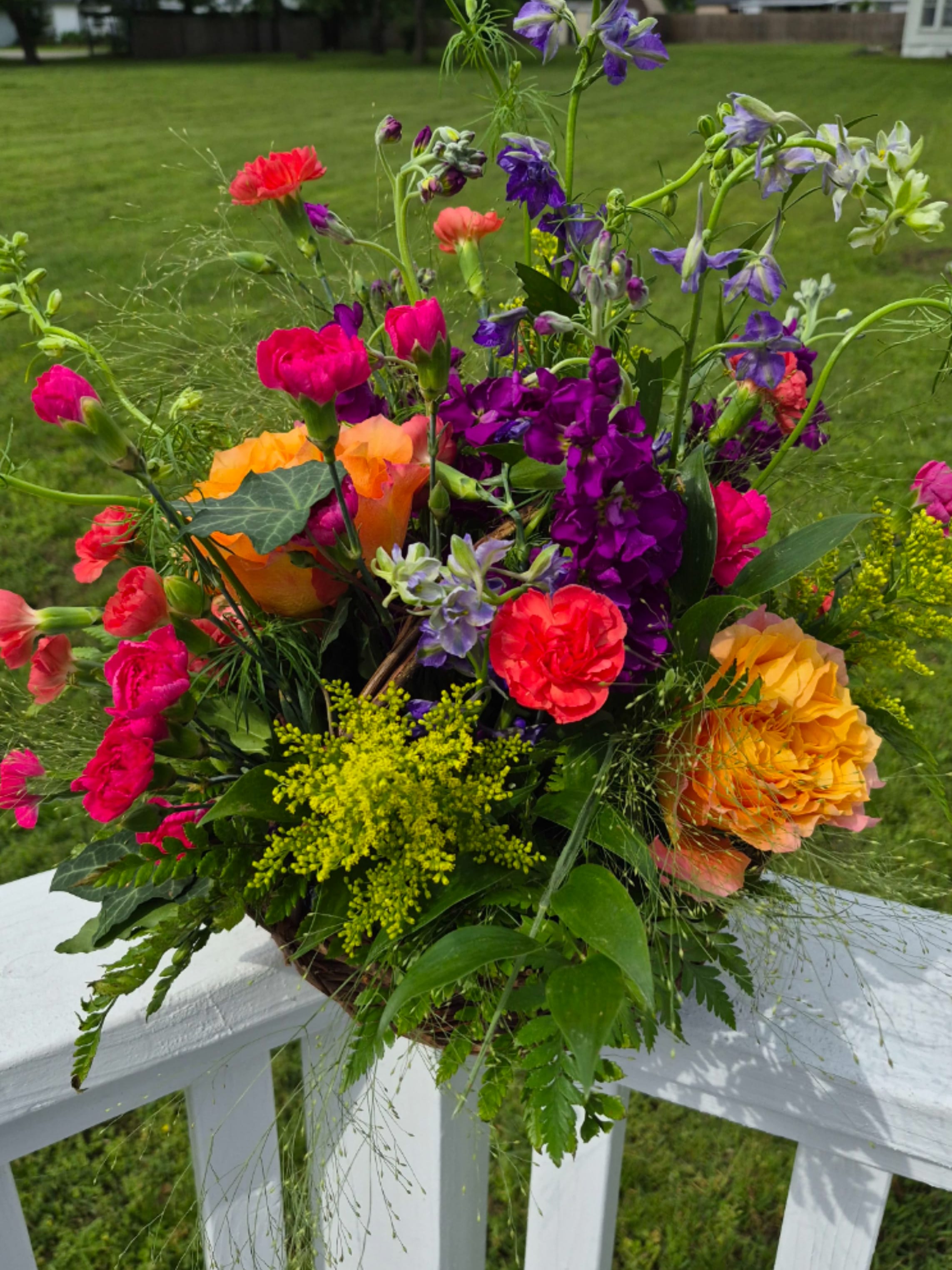 Meadow Elegance - Arranged in a rustic woven basket, this design blends organic movement with polished sophistication. Perfect for meaningful gifts, celebrations, or adding a touch of natural beauty to any setting, this arrangement offers timeless charm with a garden-inspired feel. 