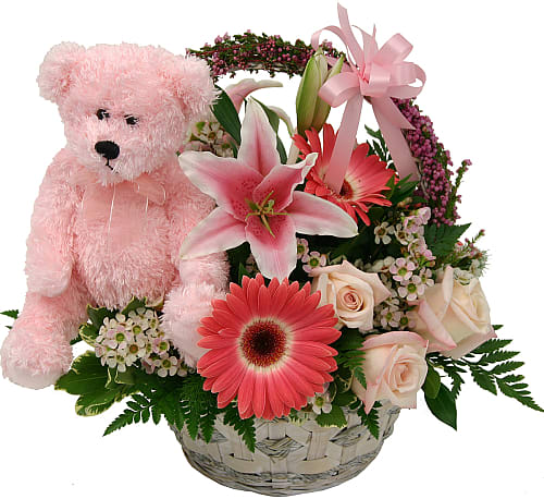 Pink teddy bear beside a basket of pink and white flowers
