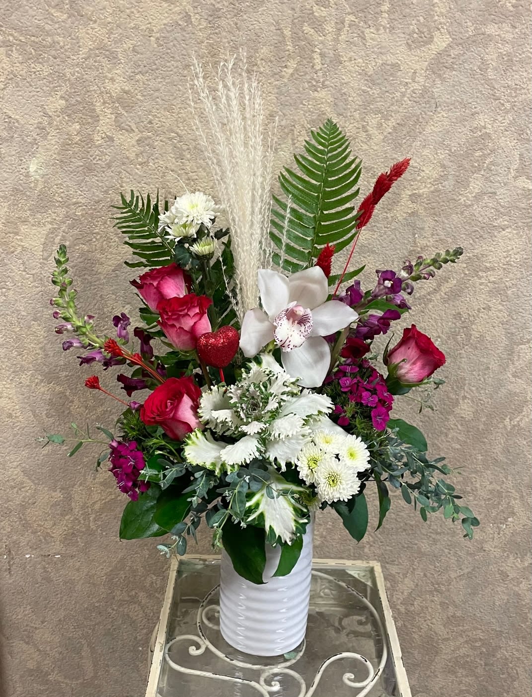 Tall mixed bouquet in a white vase with red, white, and purple flowers