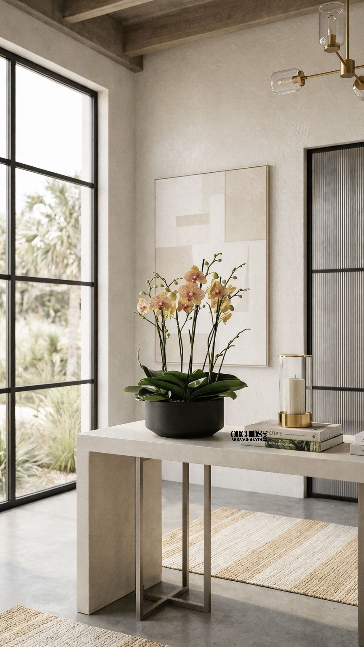 Potted orchid arrangement with pale pink blooms in a black container