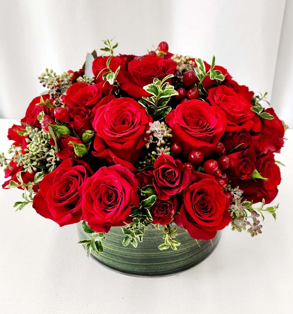 In Love With You - A dense cluster of vivid red roses fills a low, rounded glass bowl for a deeply romantic birthday bouquet, anniversary roses, or just because day arrangement that reads as both elegant and intoxicating. The arrangement is designed to make the person you're thinking of feel cherished-rich red petals packed close together create a lush, dramatic impression that says "I love you" without words.  Can be made in other colors. Call us to let us know your preference. 562-437-4106  Handcrafted to impress your loved one. 