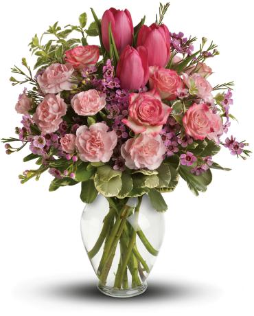 Pink tulips and roses arranged in a clear glass vase