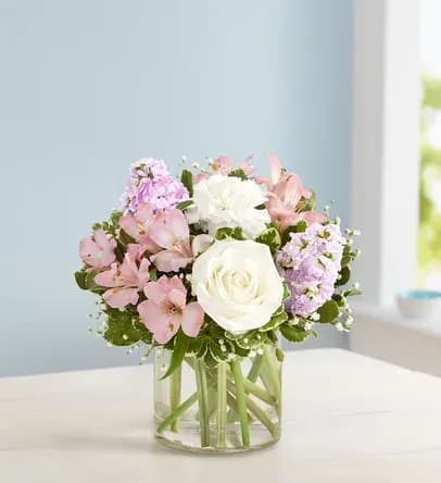 Pink and white flower arrangement in a clear glass vase