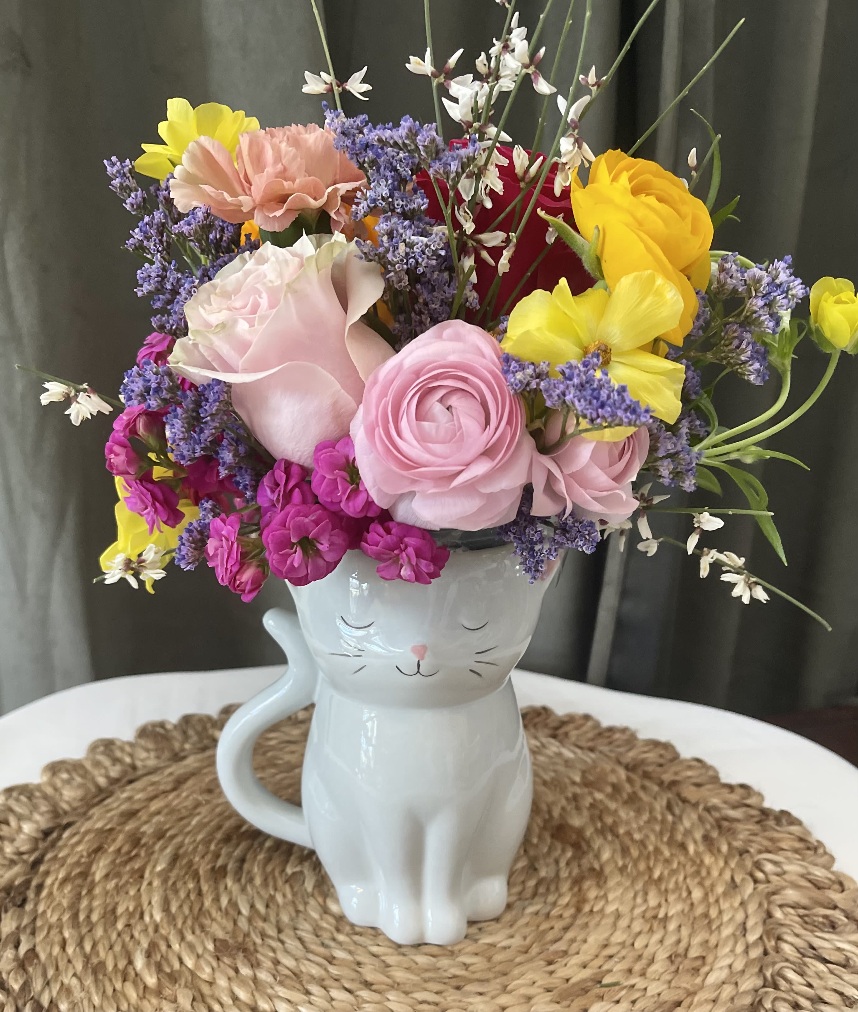 Colorful bouquet in a white cat-shaped mug vase