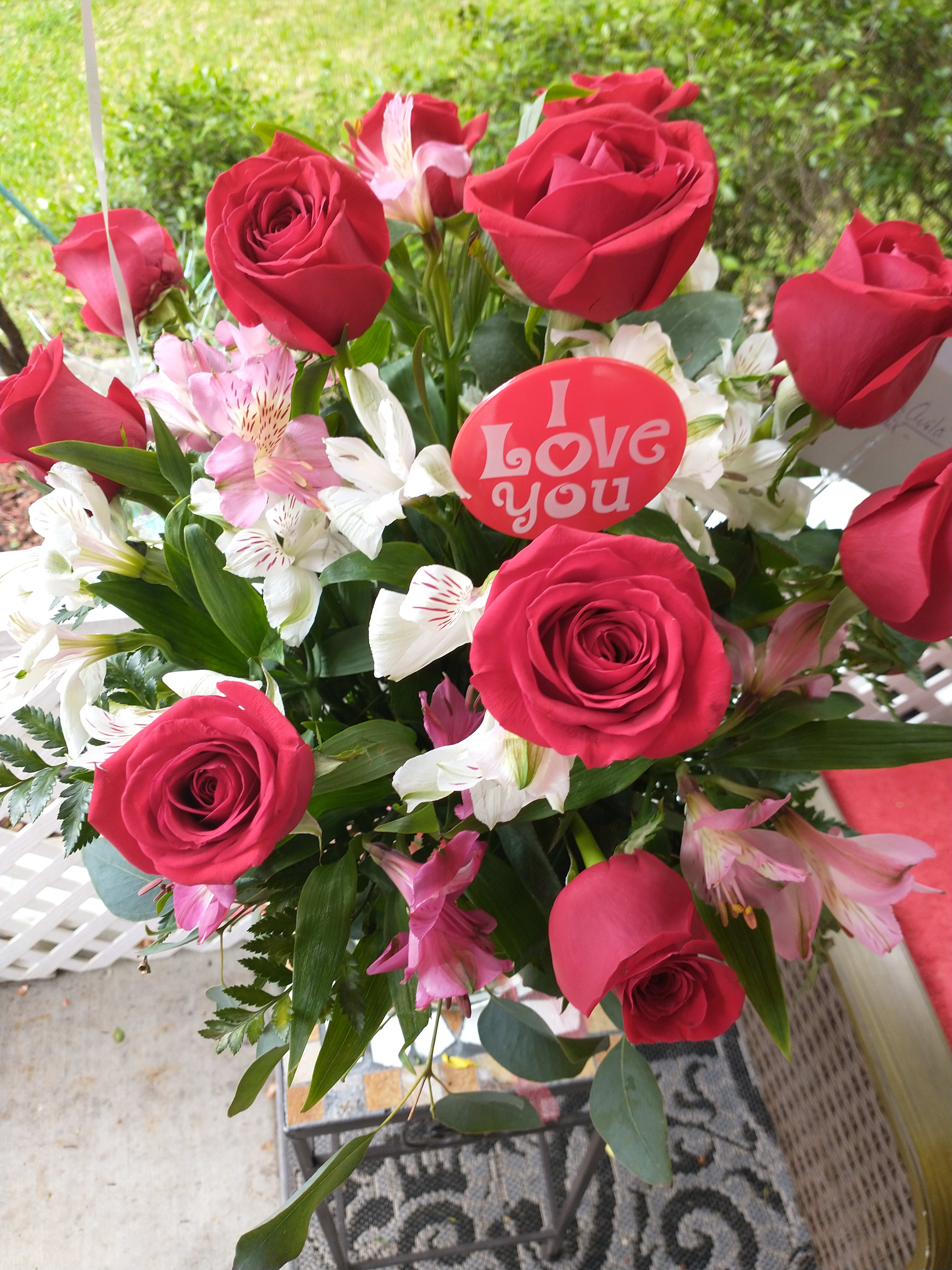 Bouquet of red roses and pink-white alstroemeria with a love-you pick