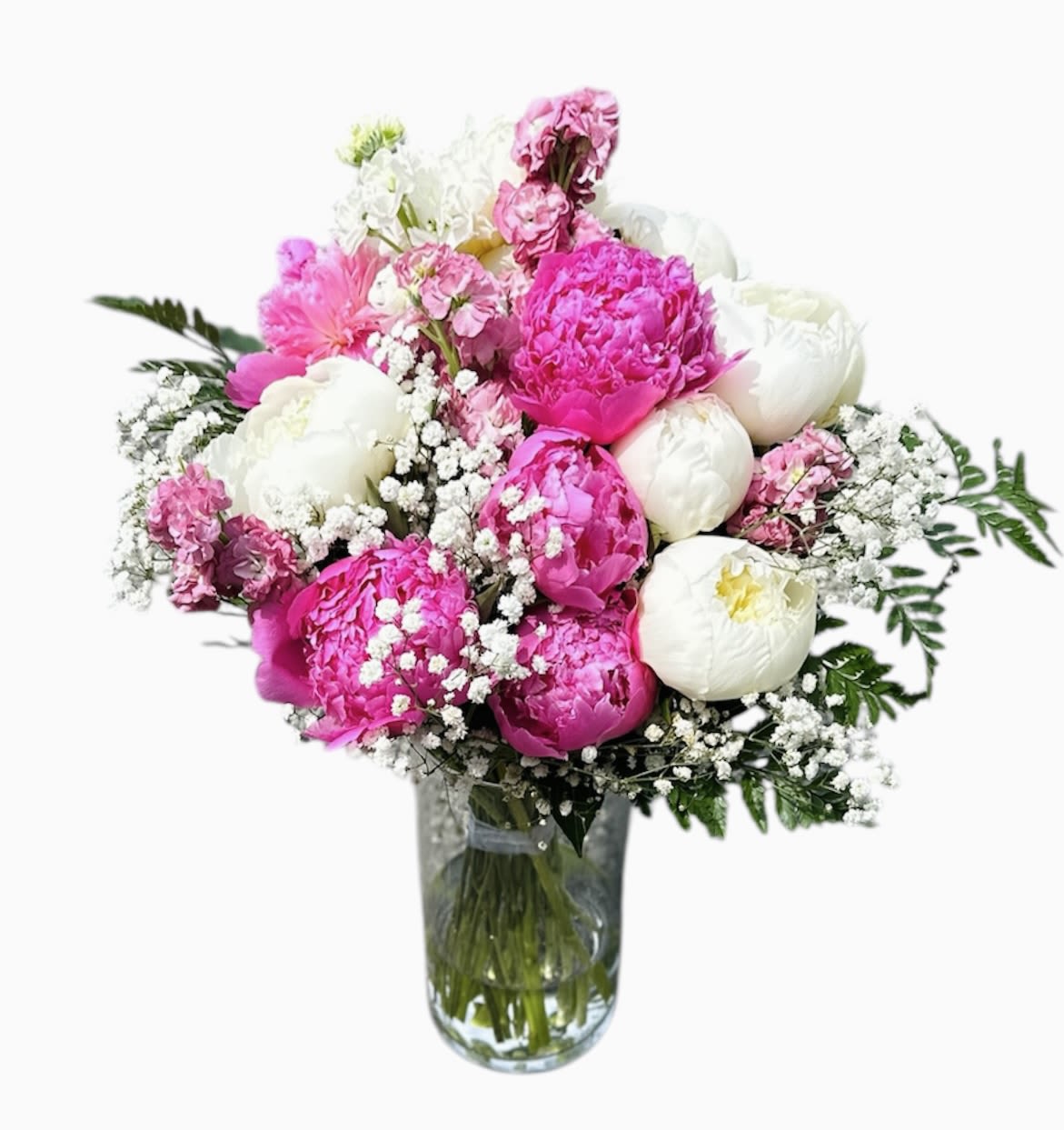 Pink and white peonies in a glass vase with baby's breath