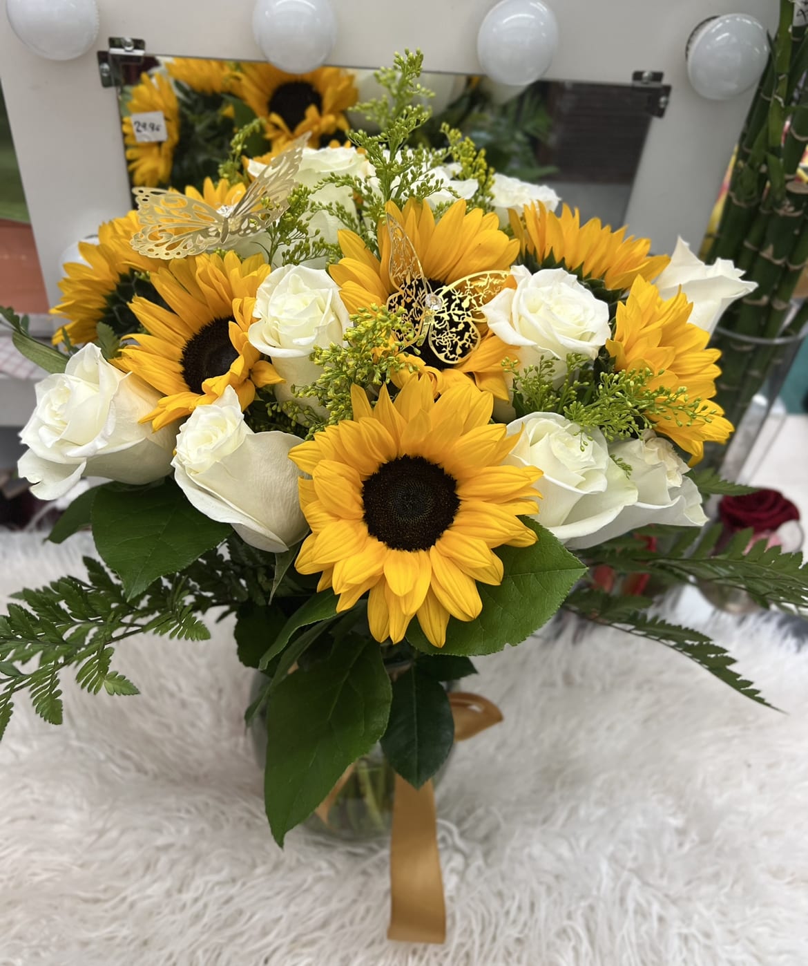 Bouquet of sunflowers and white roses in a glass vase