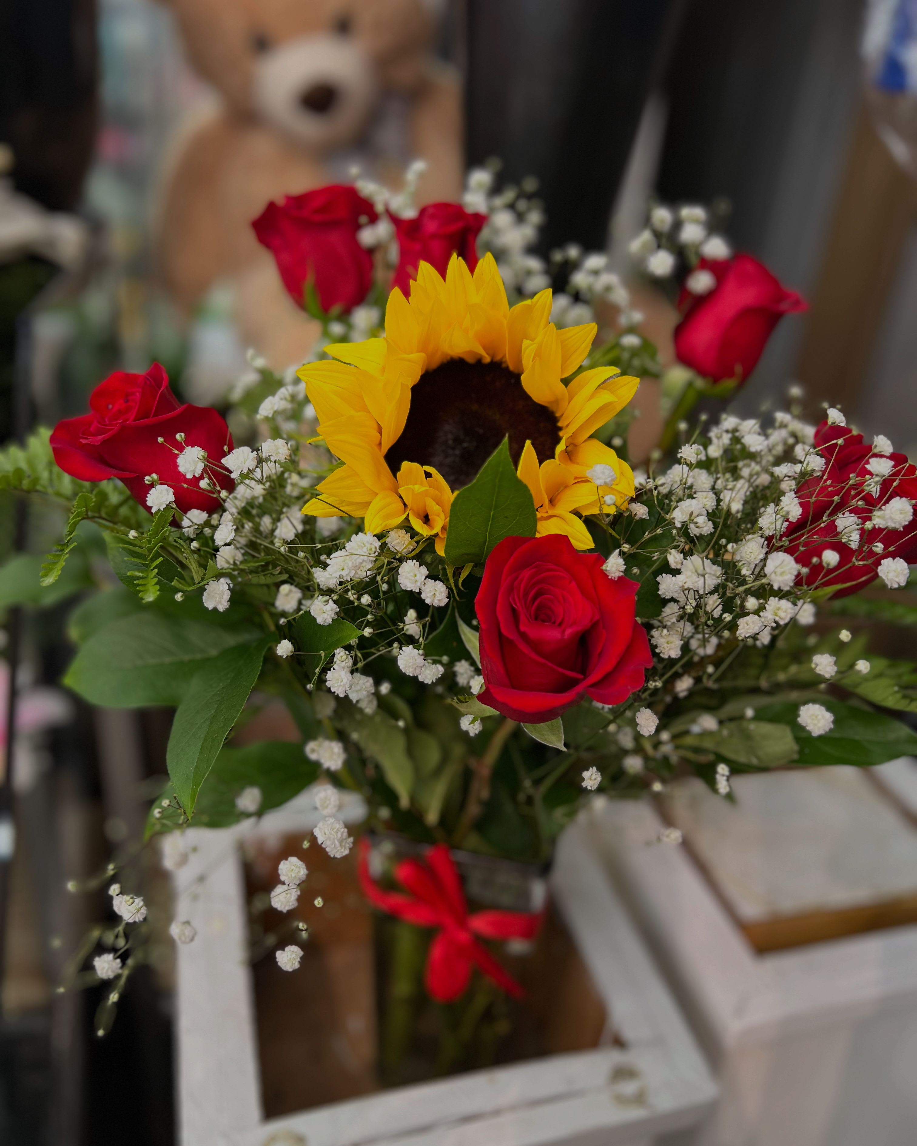 Bouquet of red roses and a sunflower with baby's breath