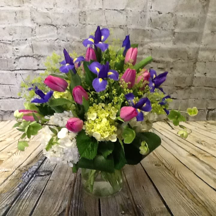 Bouquet of purple irises and pink tulips in a glass vase