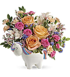 Peach and pink rose arrangement with lilies in a white ceramic unicorn container