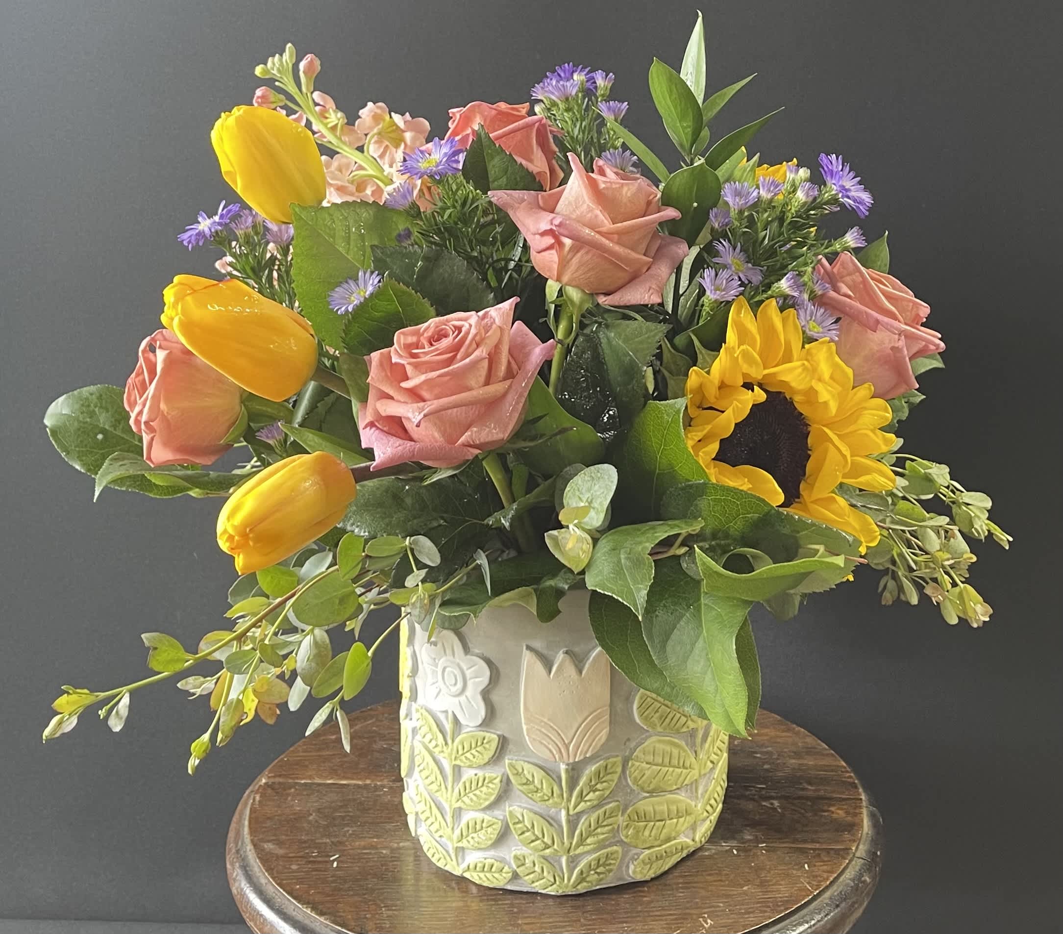 Bouquet of pink roses and yellow tulips in a decorative ceramic vase