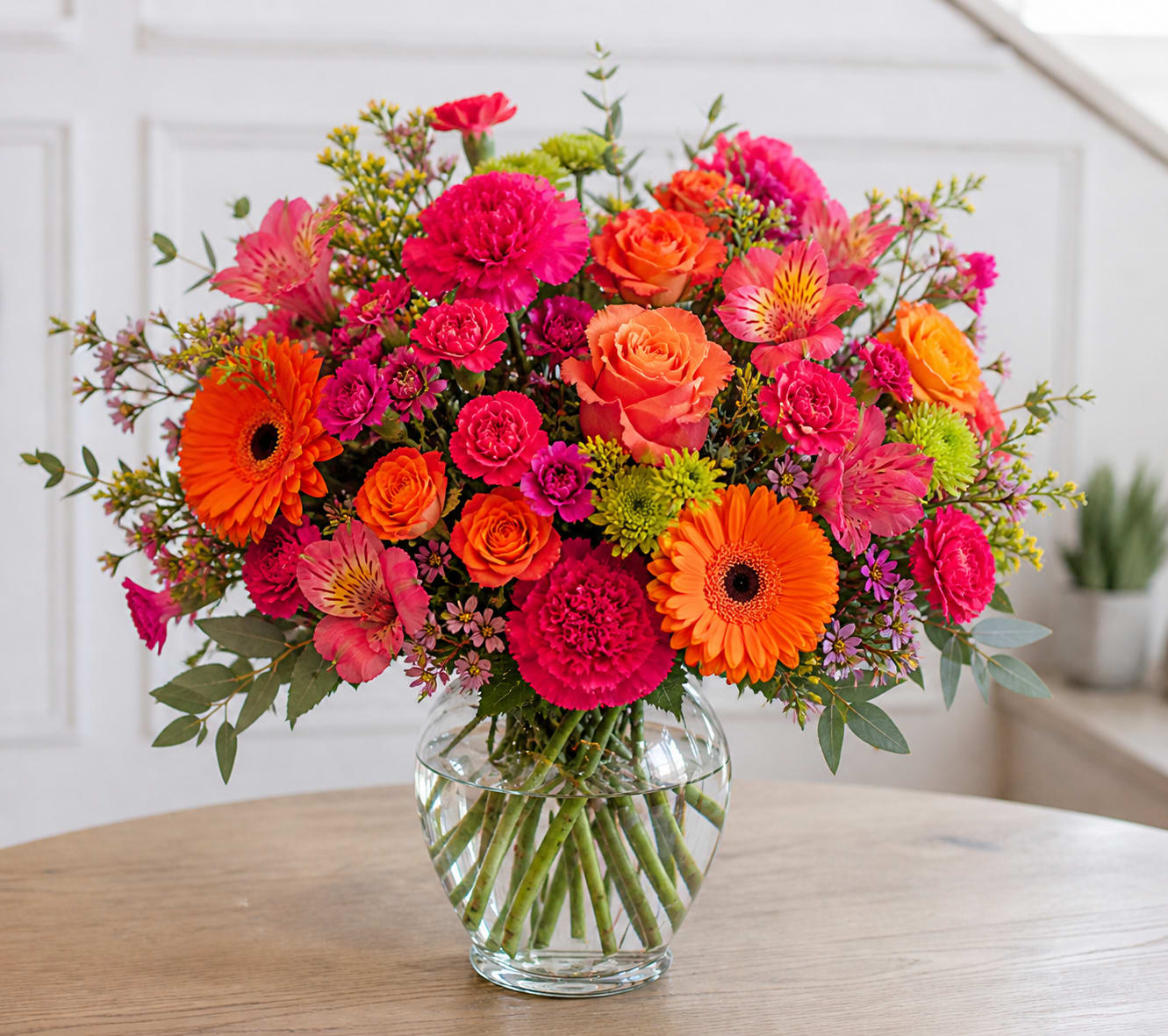 Bright &amp; Cheerful - Mother’s Day Edition - Let us create something joyful and full of life for Mom!  Our Bright &amp; Cheerful arrangements are designed in a vibrant palette of hot pinks, bright oranges, sunny yellows, and playful pops of color. Bursting with energy and texture, each design is arranged in a lush, garden-inspired style that feels fresh, fun, and full of personality.  Perfect for celebrating Mom in a bold and uplifting way, this arrangement is made to stand out and make her smile.  Choose your preferred size, and we’ll take care of the rest.  Flowers and exact varieties will vary based on availability while maintaining the overall color palette and style. Photo shown reflects our Signature size.