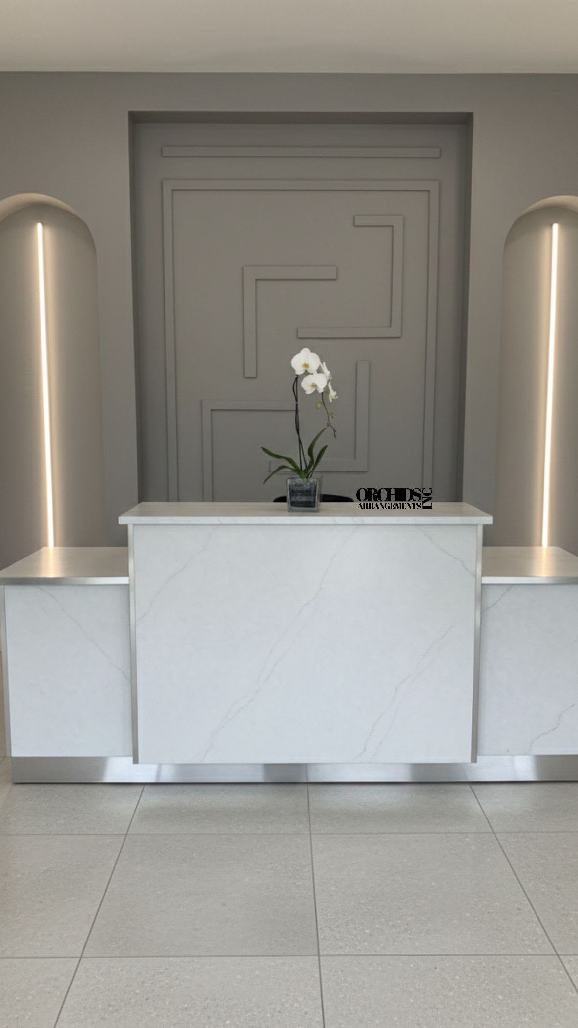 White orchid in a small square vase on a marble reception desk