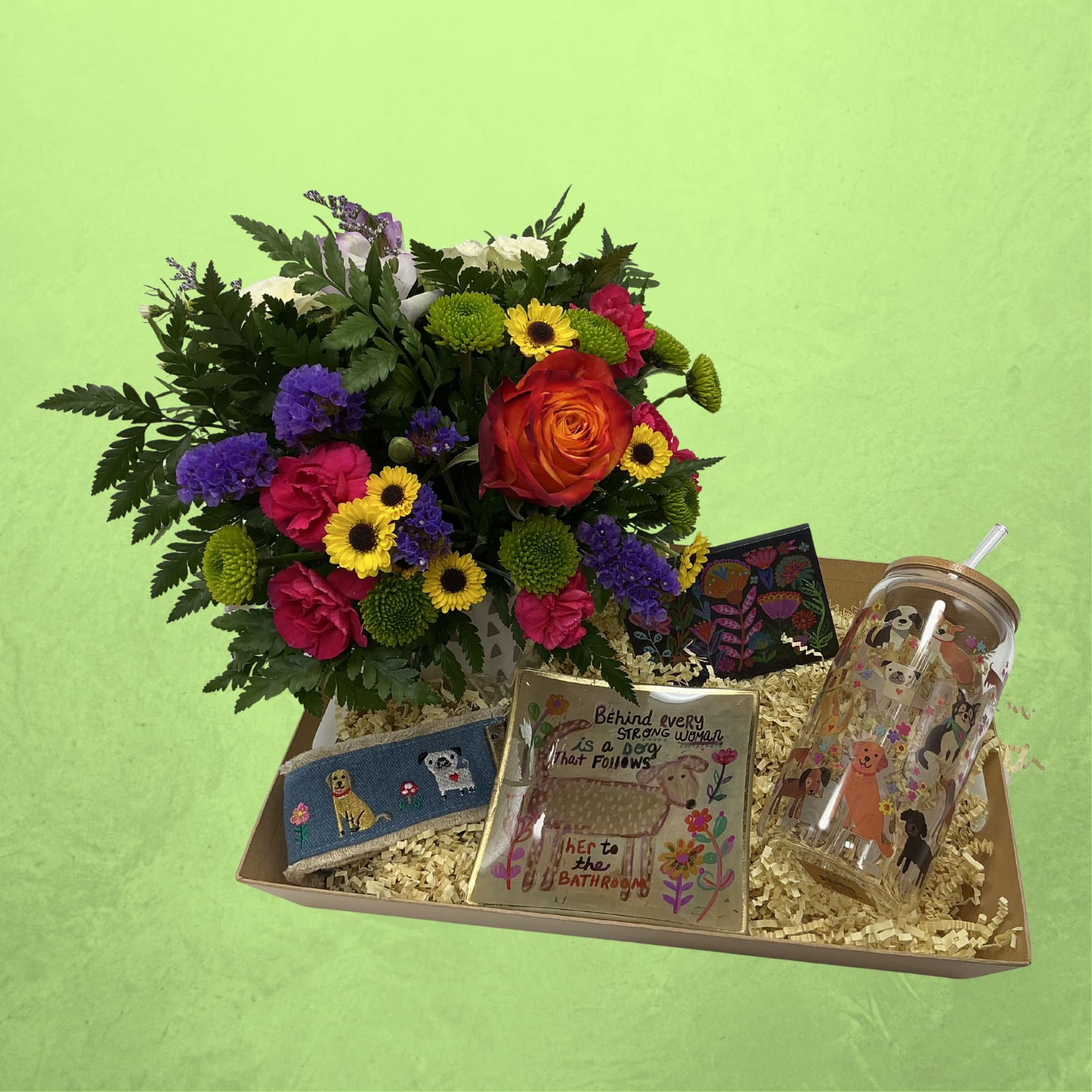 Bark &amp; Bloom Box - Celebrate the love of a dog mom this Mother’s Day with the Bark &amp; Bloom Gift Box   This curated set features a fresh floral arrangement in a keepsake mug, a dog-themed tumbler for on-the-go sips, a cute dog keychain, and a glass trinket dish that reads: “behind every strong woman is a dog that follows her to the bathroom.” To top it off, we’ve included a cute purse sized pack of lint/fur remover sheets—because dog hair is part of the love.  Thoughtful, practical, and full of personality, it’s the perfect gift for moms who adore their pups. 