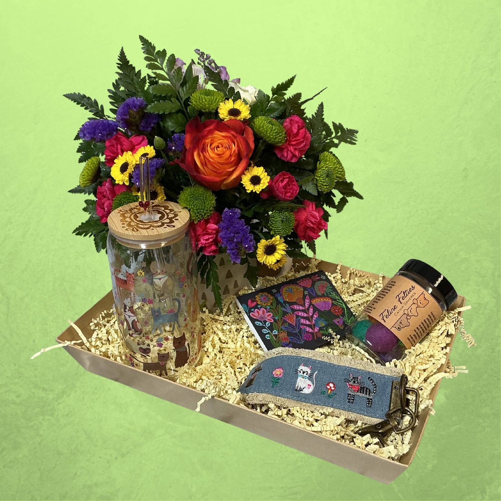 Purrs &amp; Petals Giftbox - Celebrate the love of a Cat Mom this Mother’s Day with the Purrs &amp; Petals Gift Box   This curated set features a beautiful fresh floral arrangement in a keepsake mug, a cat-themed tumbler for cozy sips, a cute cat keychain, and a set of Feline Felties catnip-infused felt spheres—perfect for keeping her feline friend happily entertained. To top it off, we’ve included a purse sized pack of lint/fur remover sheets—because cat hair is part of the love.  Thoughtful, practical, and full of personality, it’s the perfect gift for moms who adore their cats.