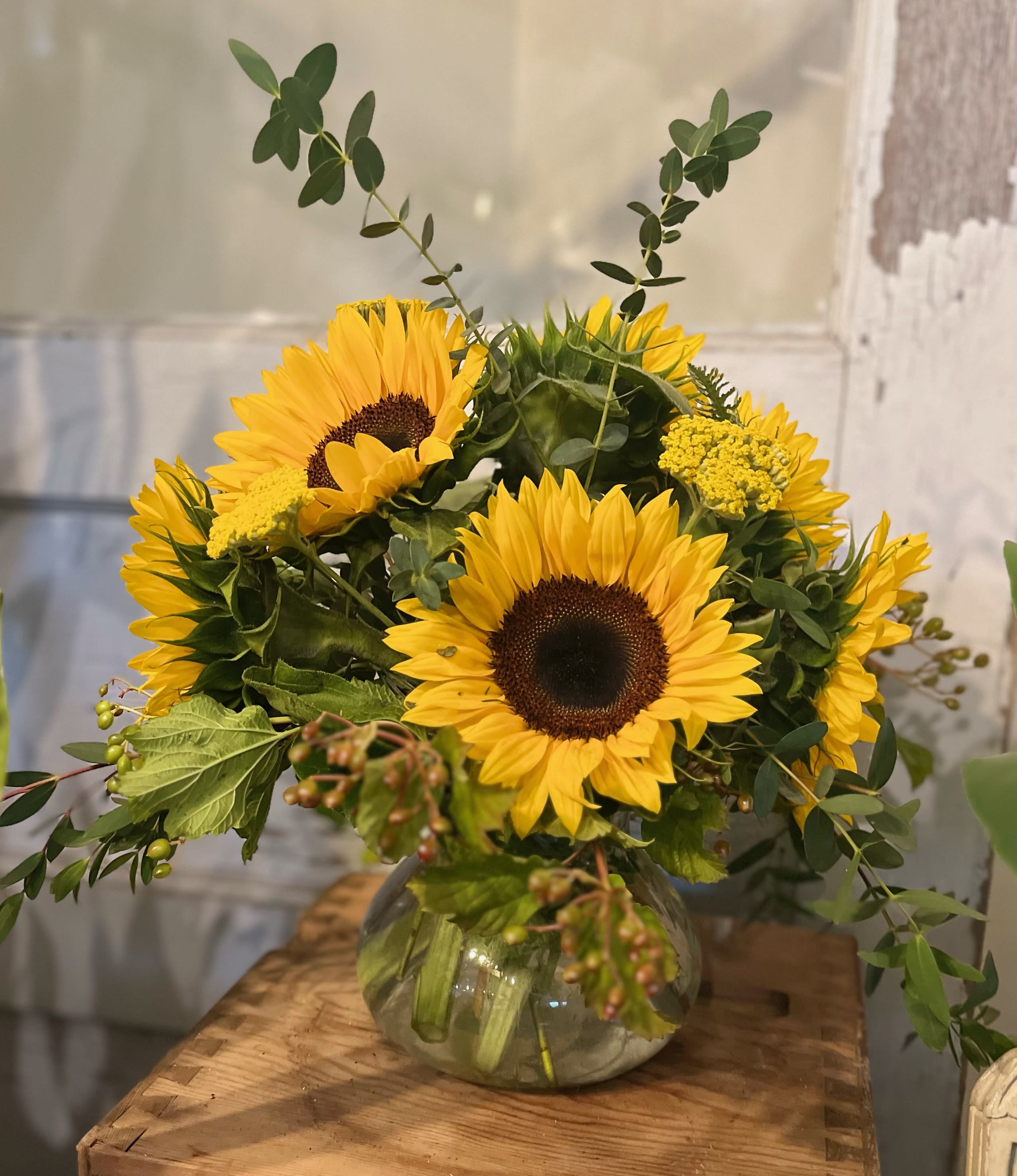 Sunflower arrangement in a round glass vase