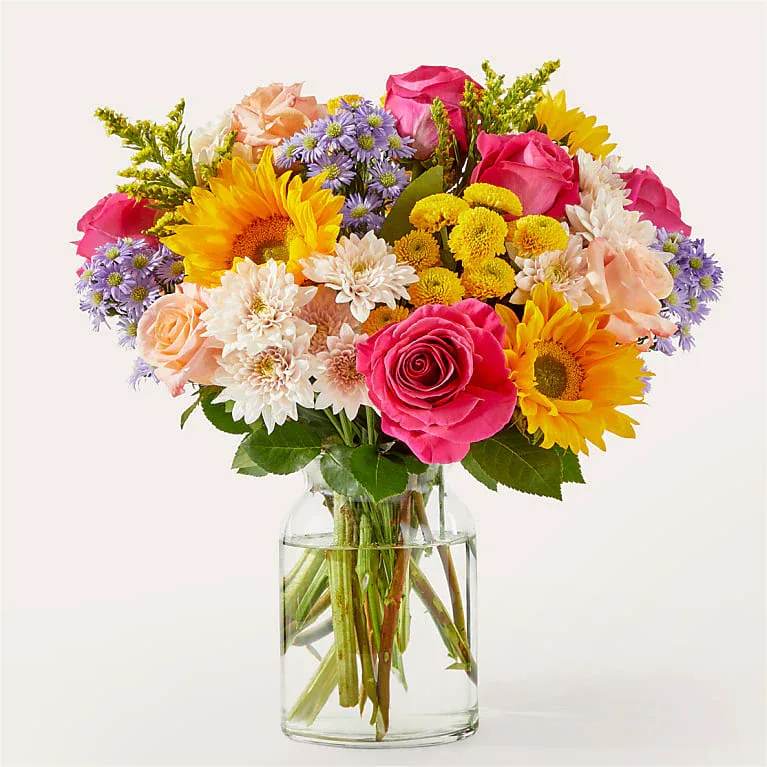 In Good Spirits Bouquet - A colorful blend of roses, sunflowers, and poms to celebrate life events, cheer someone up, or simply make your day brighter.  Bloom Details Rose Sunflower Solidago