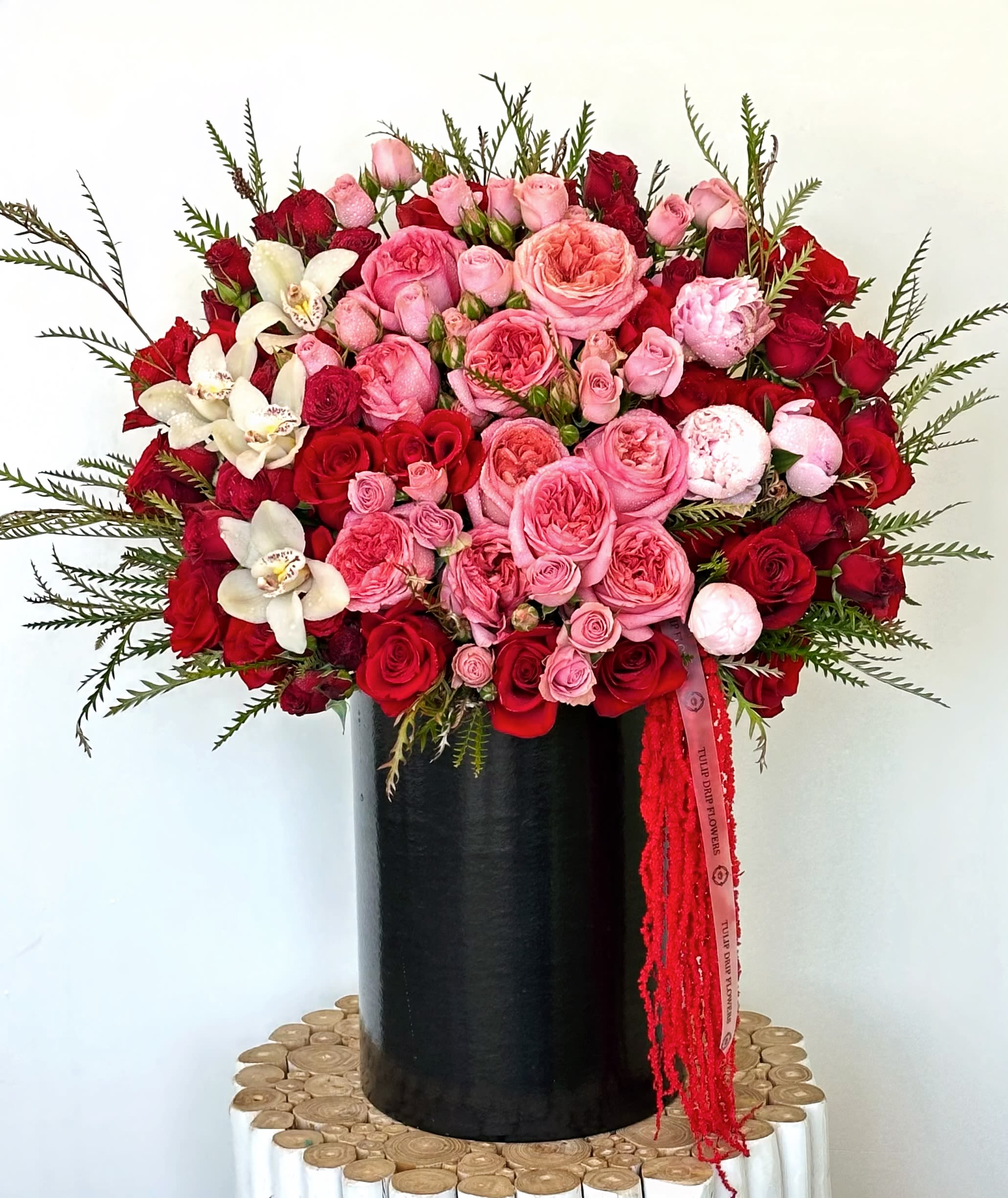 Large bouquet of pink and red roses in a black vase