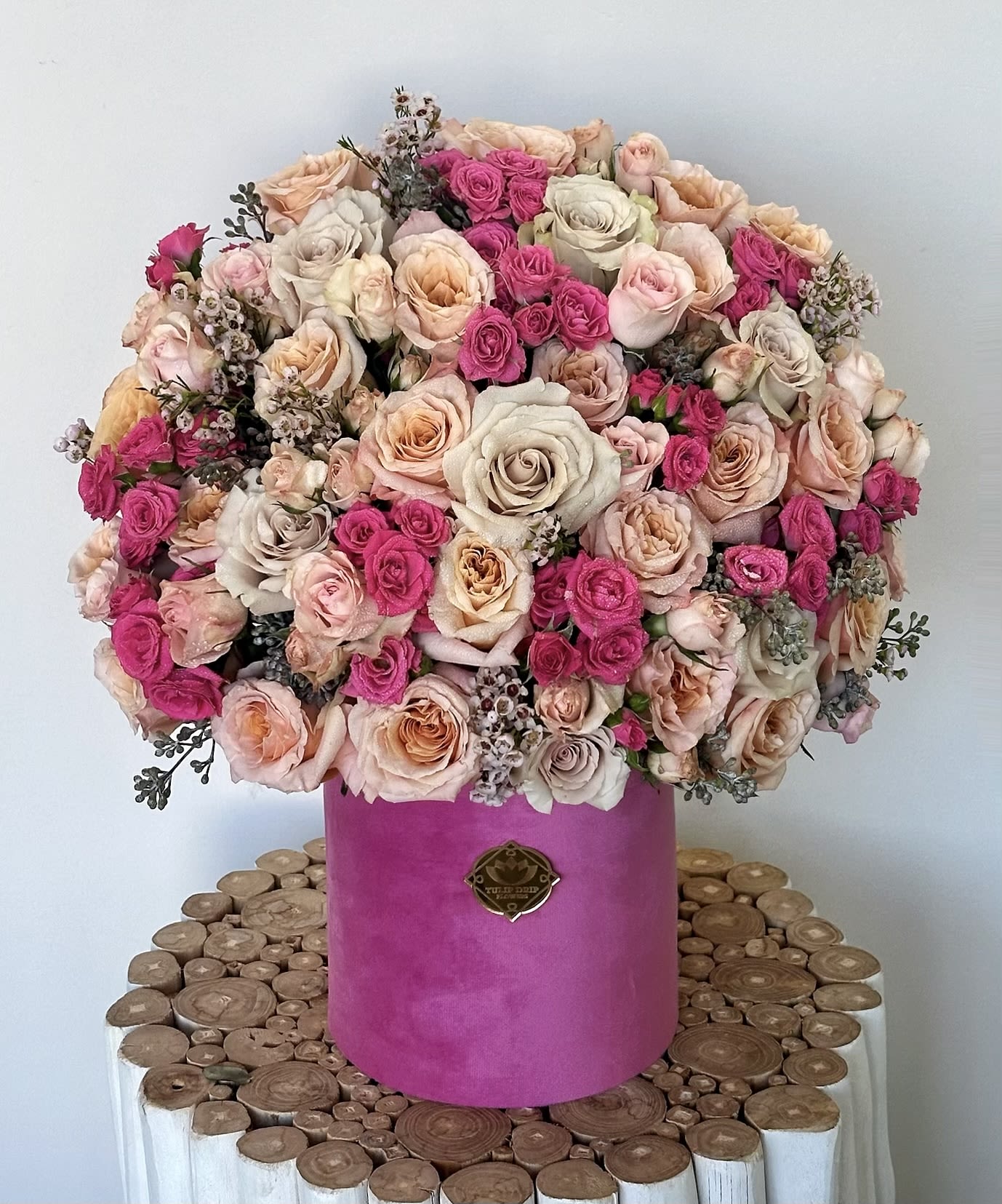 Large bouquet of pink and blush roses in a magenta hatbox