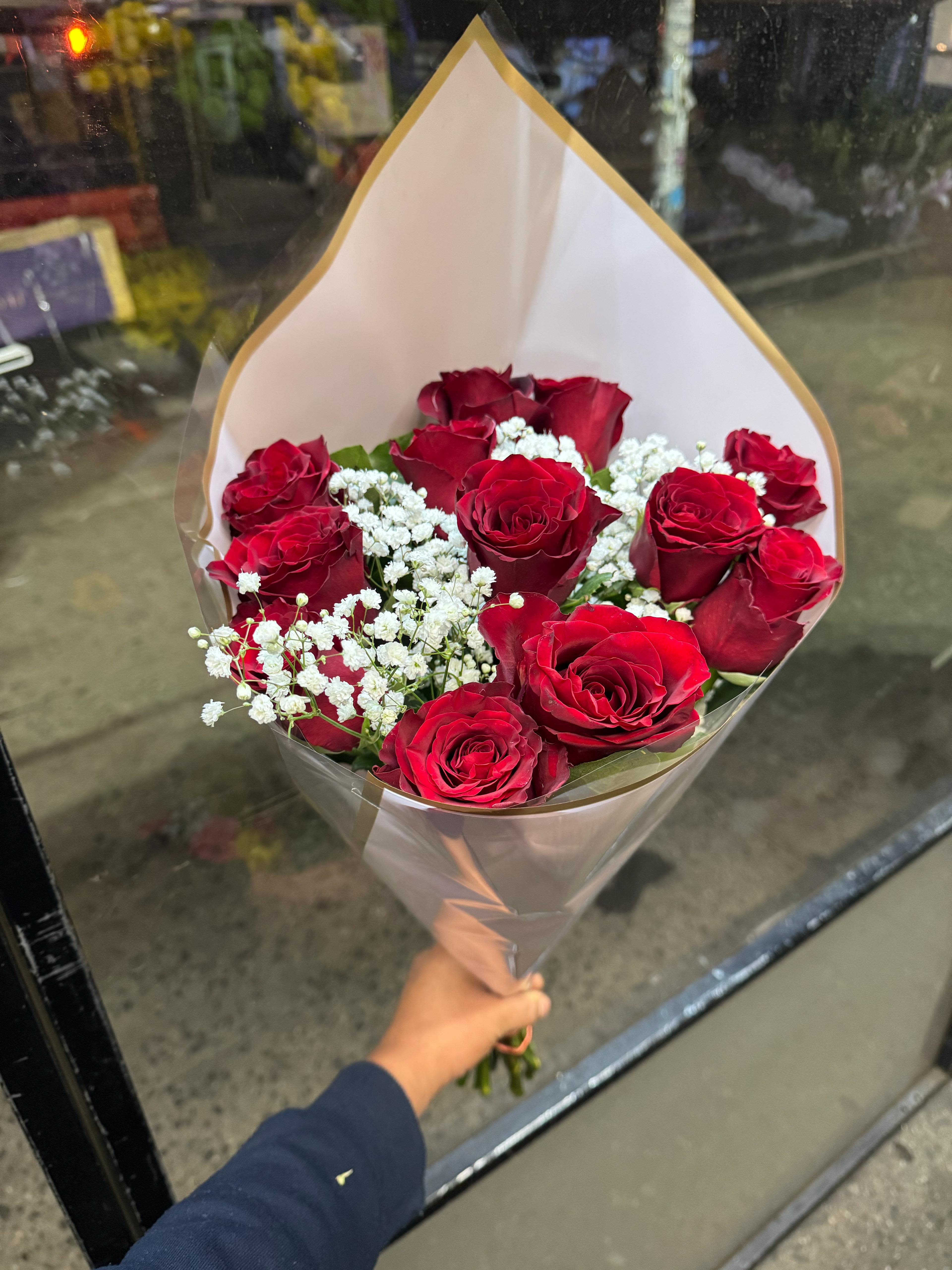 Bouquet of red roses with white baby's breath in clear wrap