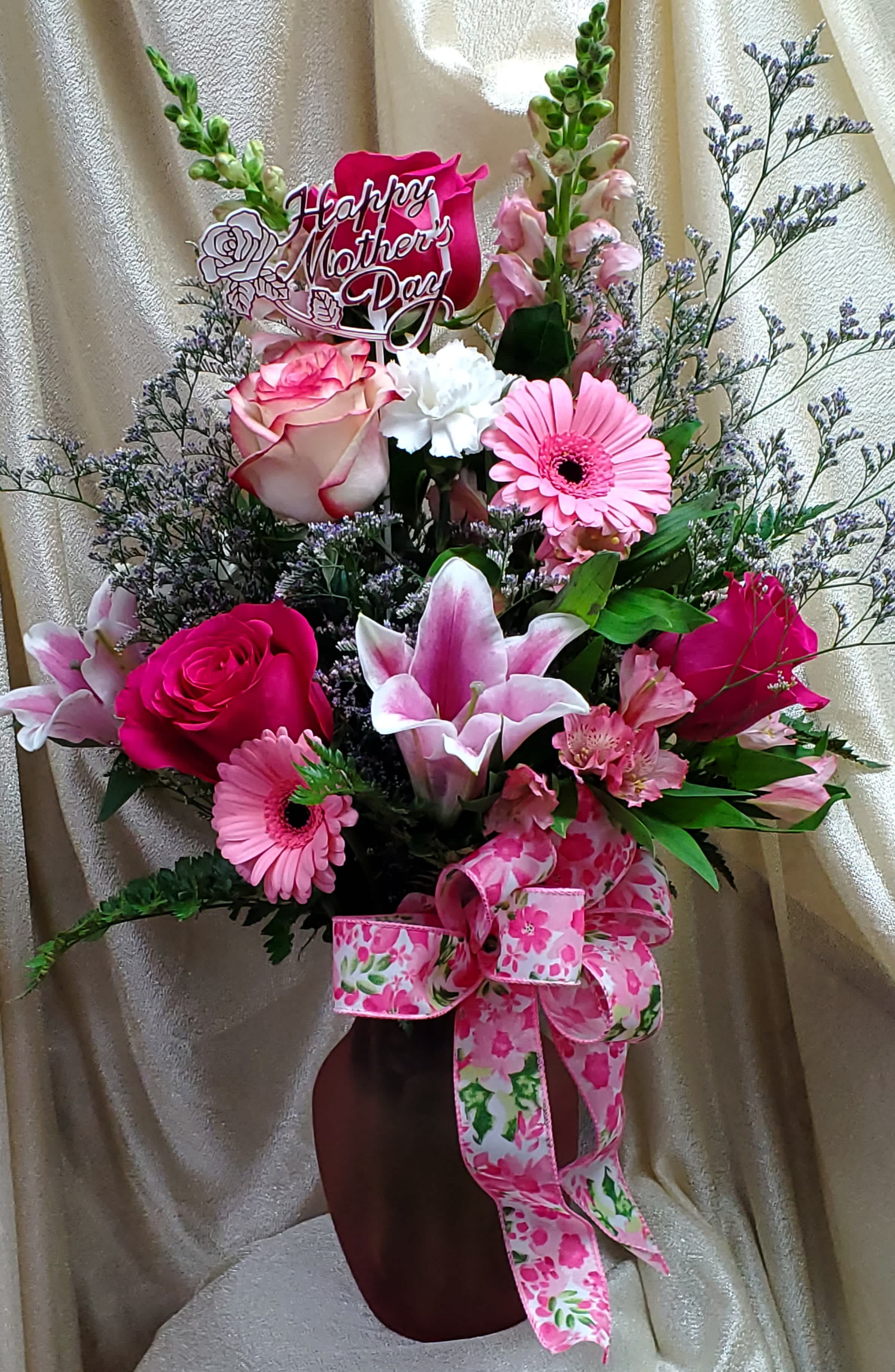 Pink and white mixed flower arrangement in a vase with a Mother's Day sign