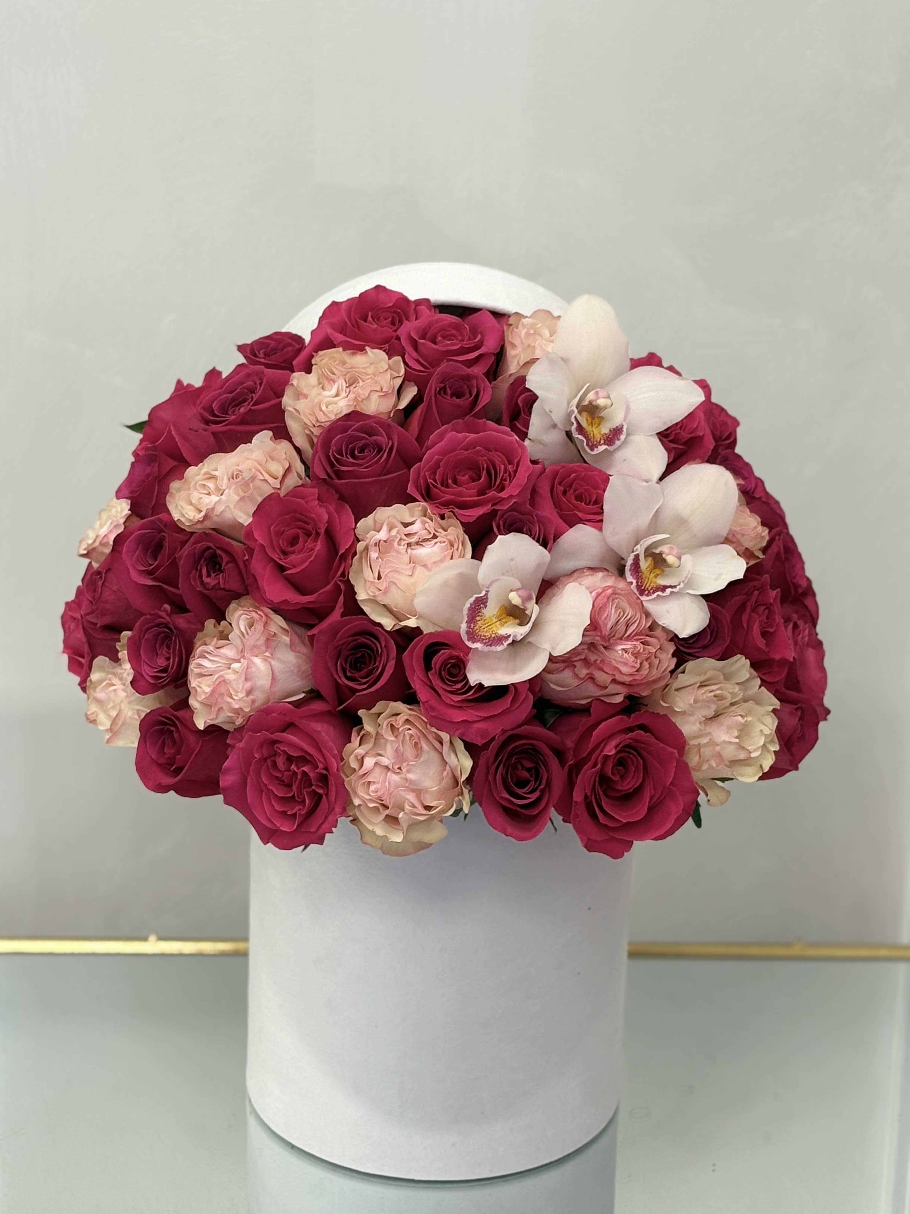 Bouquet of pink and blush roses with white orchids in a white hat box