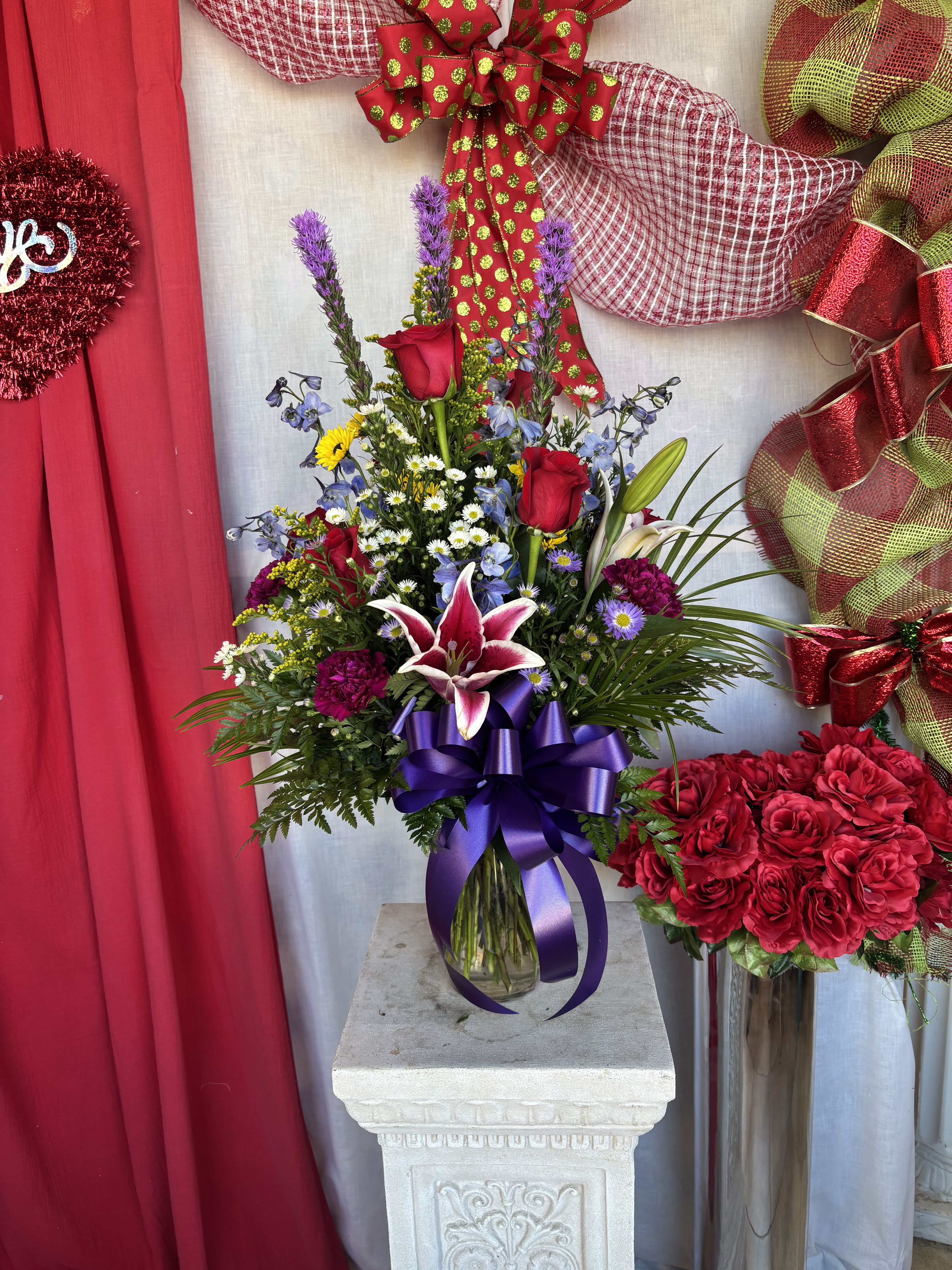 Mixed bouquet with red roses and lilies in a glass vase