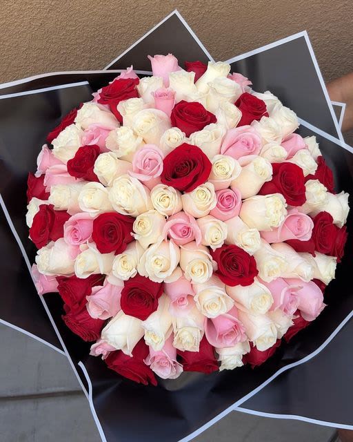 Love You Mom - A lush dome of tightly packed roses in vivid red, blush pink, and creamy white creates an immediate wow-this large, round flower arrangement is perfect as a birthday bouquet, anniversary roses, or a Valentine's Day gift to make Mom feel deeply loved. The saturated reds speak of passion while the soft pinks and creams read as tender and thoughtful, so the person you're sending it to will feel truly celebrated and seen.  Every bloom is layered densely for a full, polished dome shape, finished with dramatic black wrapping paper that heightens the color contrast and gives the bouquet a modern, luxurious edge. All roses, arranged for maximum visual impact and longevity; the presentation reads classic and romantic, the kind of gift that arrives looking like a special occasion.  This is an ideal choice when you want to say "Love you, Mom" for Mother's Day, her birthday, or just because-an unmistakably romantic and affectionate statement. Order in the large size pictured for a bold presentation; for best results, recut stems and place in fresh water on arrival to extend vase life.