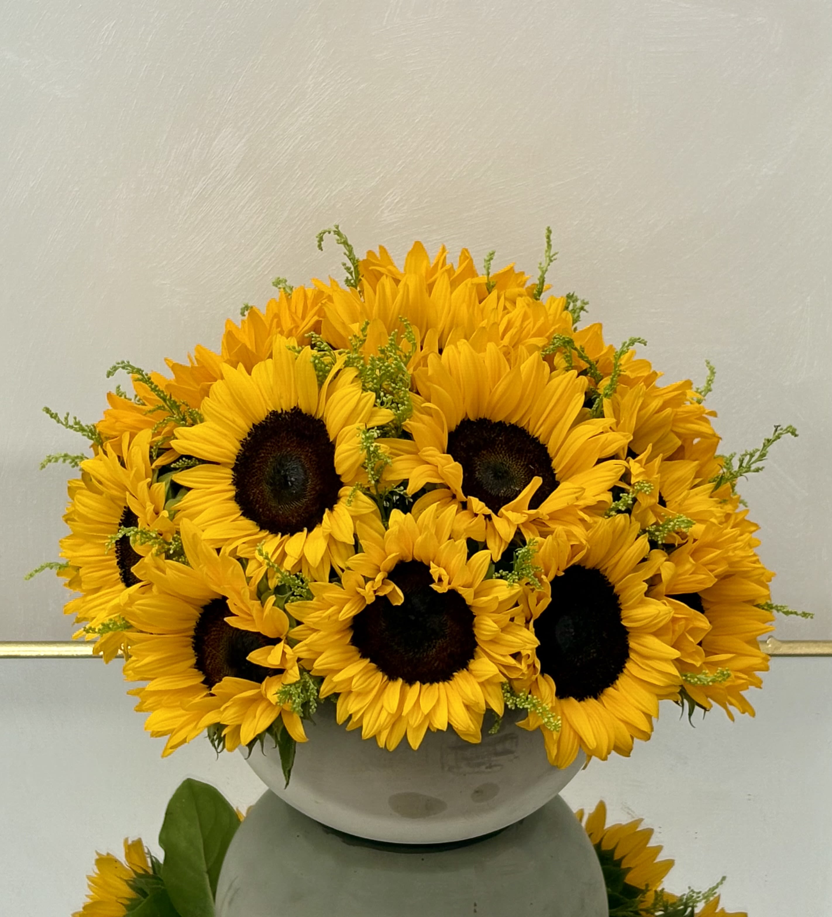 Bouquet of yellow sunflowers in a white bowl vase