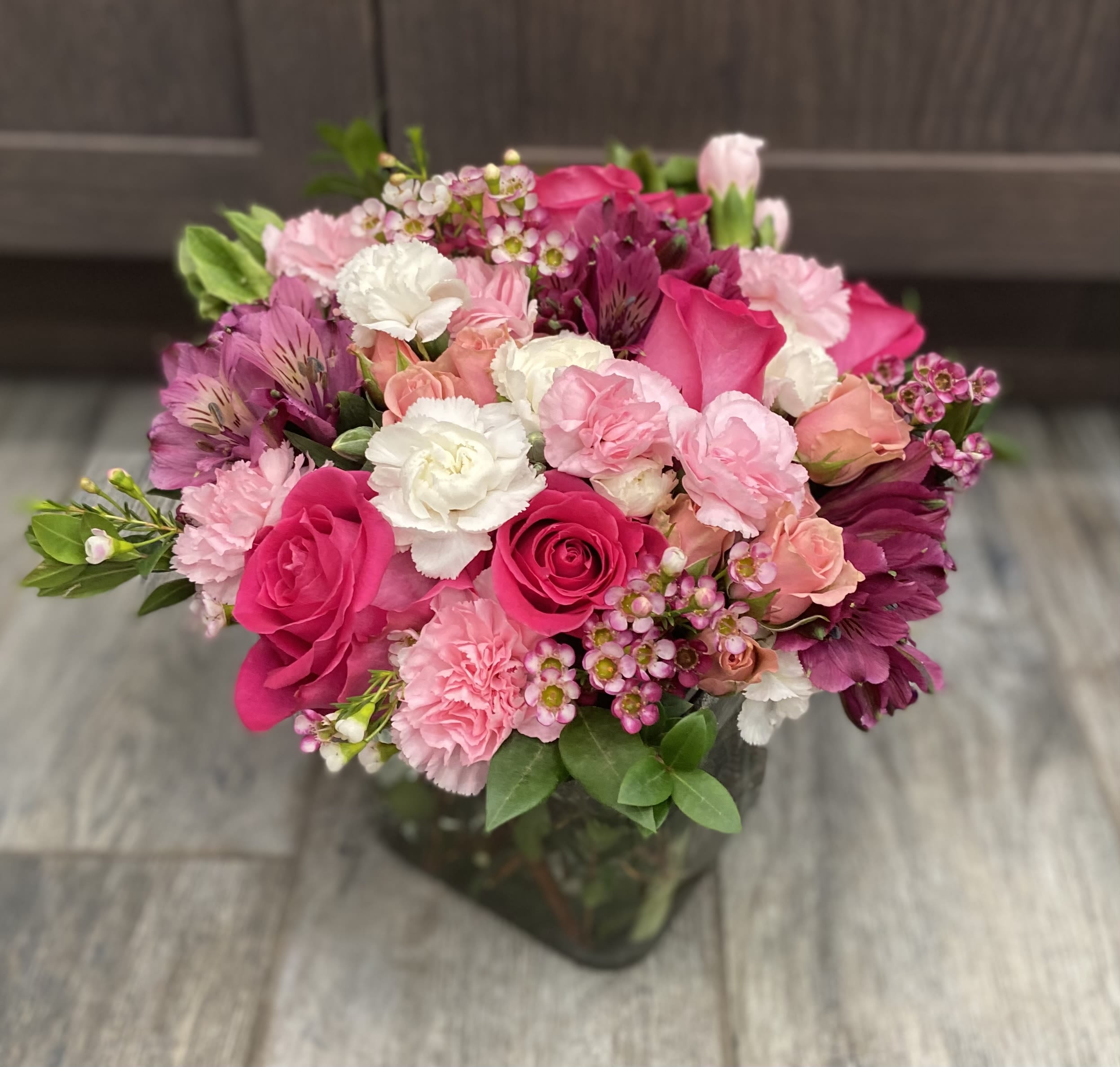 Rosé All Day - A lush, vibrant arrangement bursting with shades of pink—from soft blush to bold fuchsia—accented with creamy whites and fresh greenery. Featuring a mix of roses, carnations, and delicate filler blooms, this design is full, textured, and eye-catching. Cheerful yet romantic, it’s the perfect choice for celebrating love, friendship, birthdays, or adding a bright pop of color to any space.