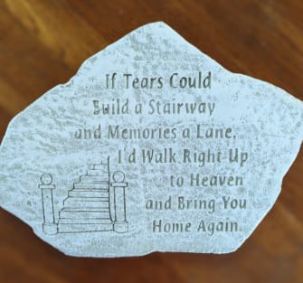 Memorial stone with a staircase illustration and engraved quote