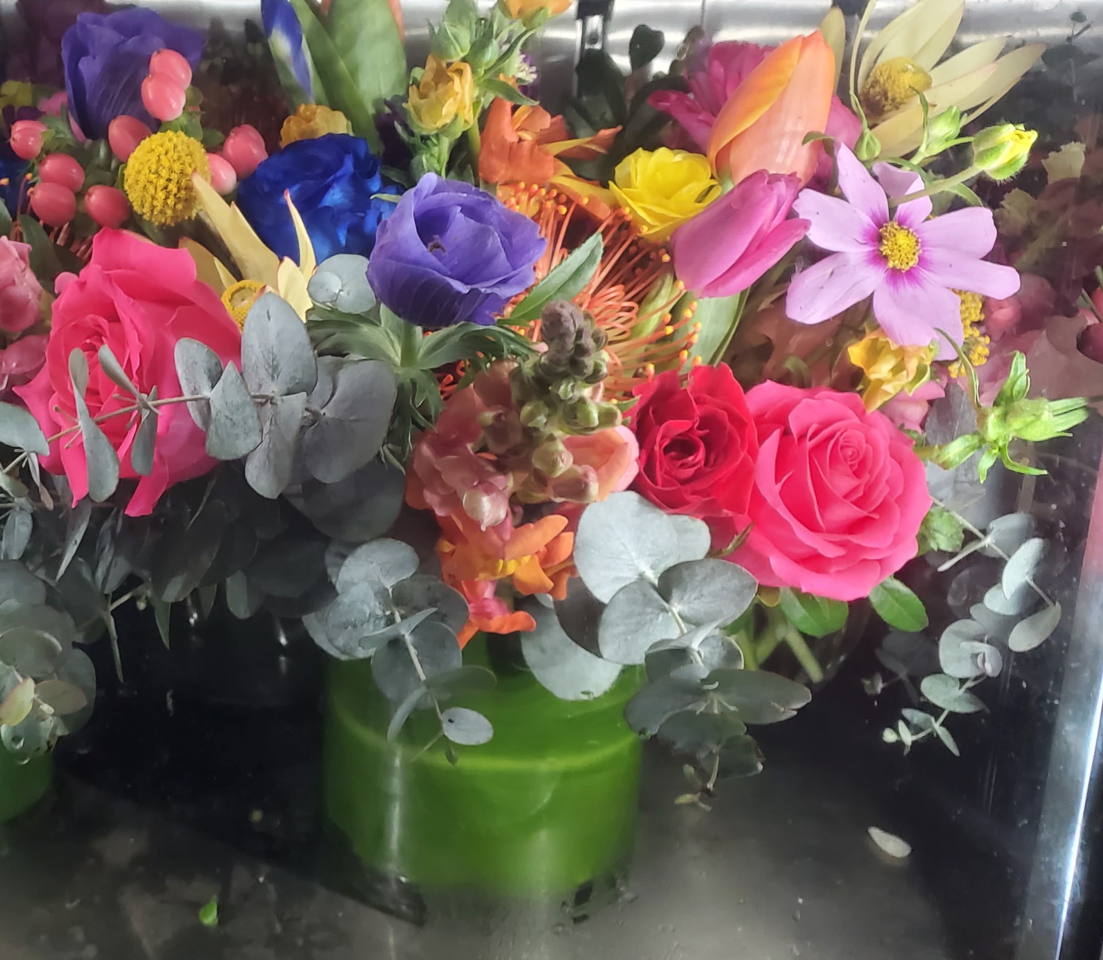 Colorful bouquet of roses and mixed flowers in a green vase