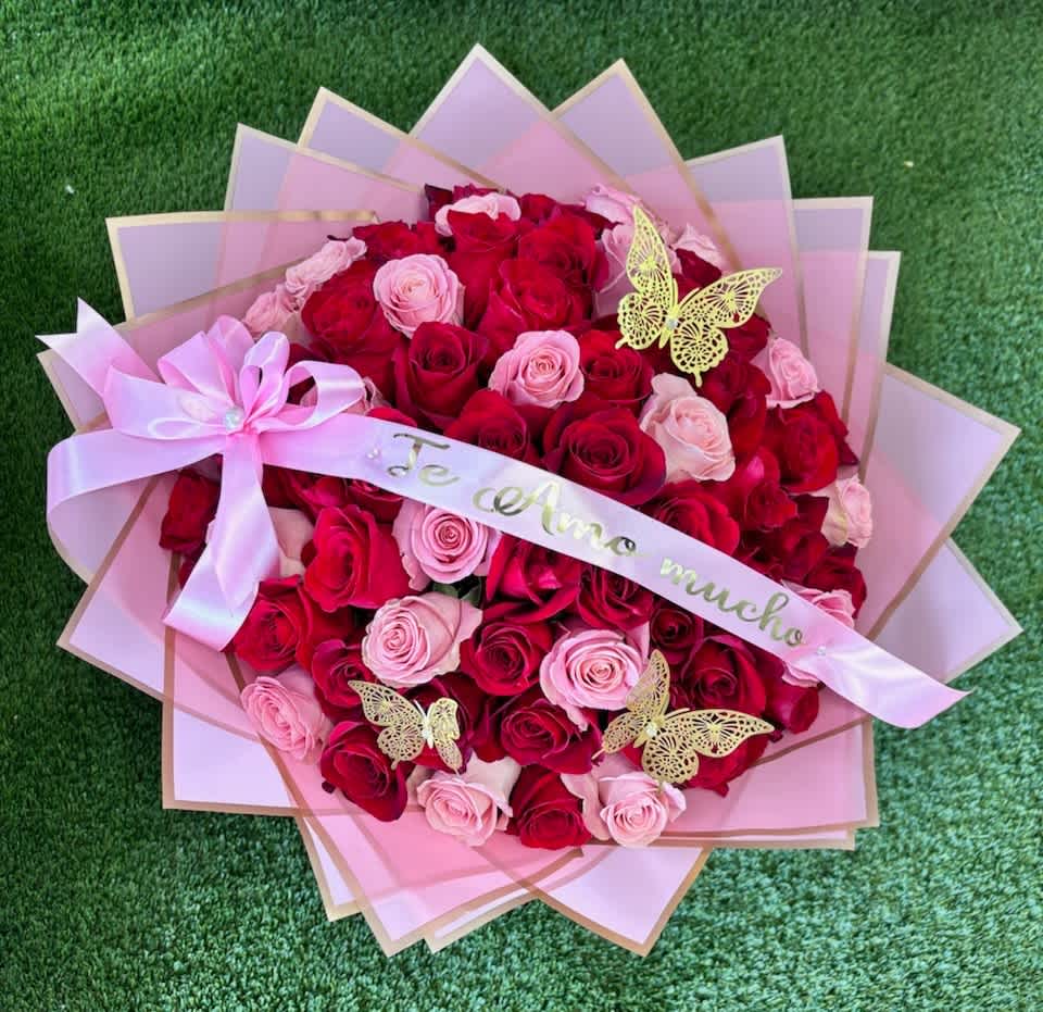 Bouquet of red and pink roses wrapped in pink paper with a ribbon