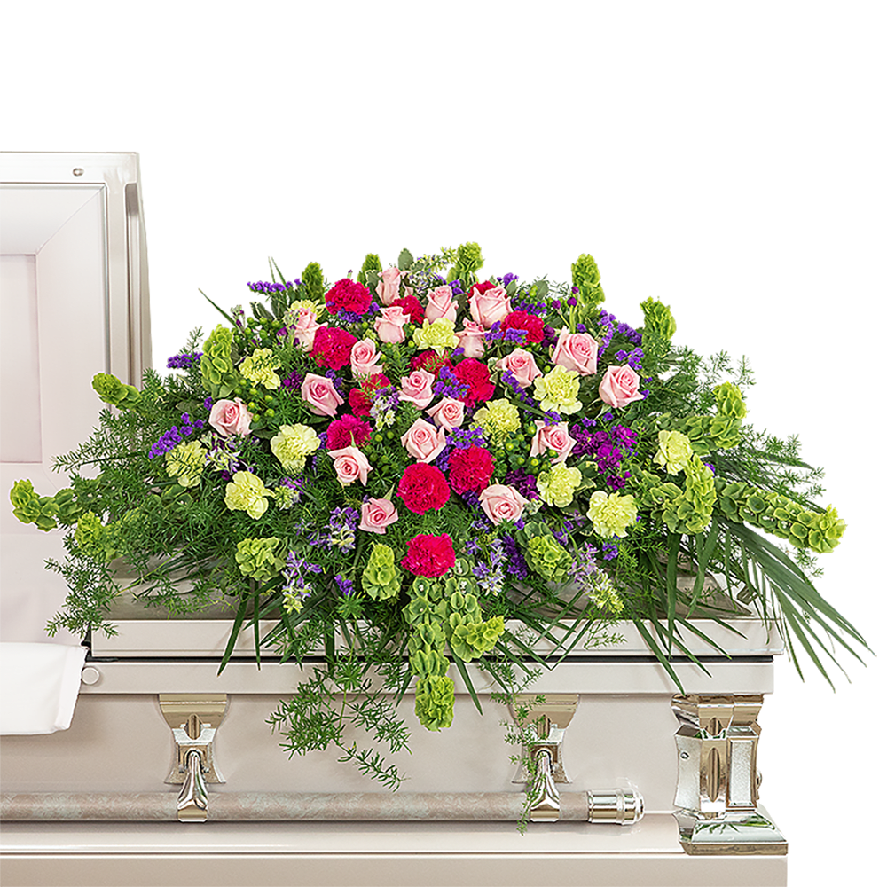 Always Remembered Casket Spray - Our Always Remembered Casket Spray is a gorgeous design for the casket with bright pinks, purples, and greens. The bright colors in this design are accomplished with roses, Bells of Ireland, Hot Pink, and green Carnations, Hypericum Berries, Larkspur, Statice, and other premium foliage. The casket spray or family flowers are typically provided by the spouse or immediate family as a heartfelt memorial from the family and is designed to sit on the lid of the casket for a funeral service or memorial.  The image shows the Deluxe arrangement.