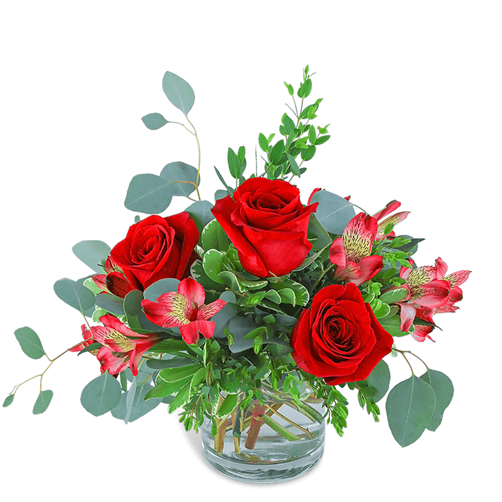 Red roses and pink alstroemeria in a clear glass vase