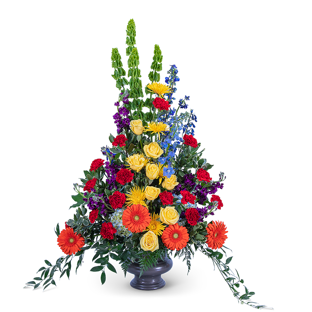 Tall mixed flower arrangement in a gray vase with orange, yellow, red, blue, and purple blooms