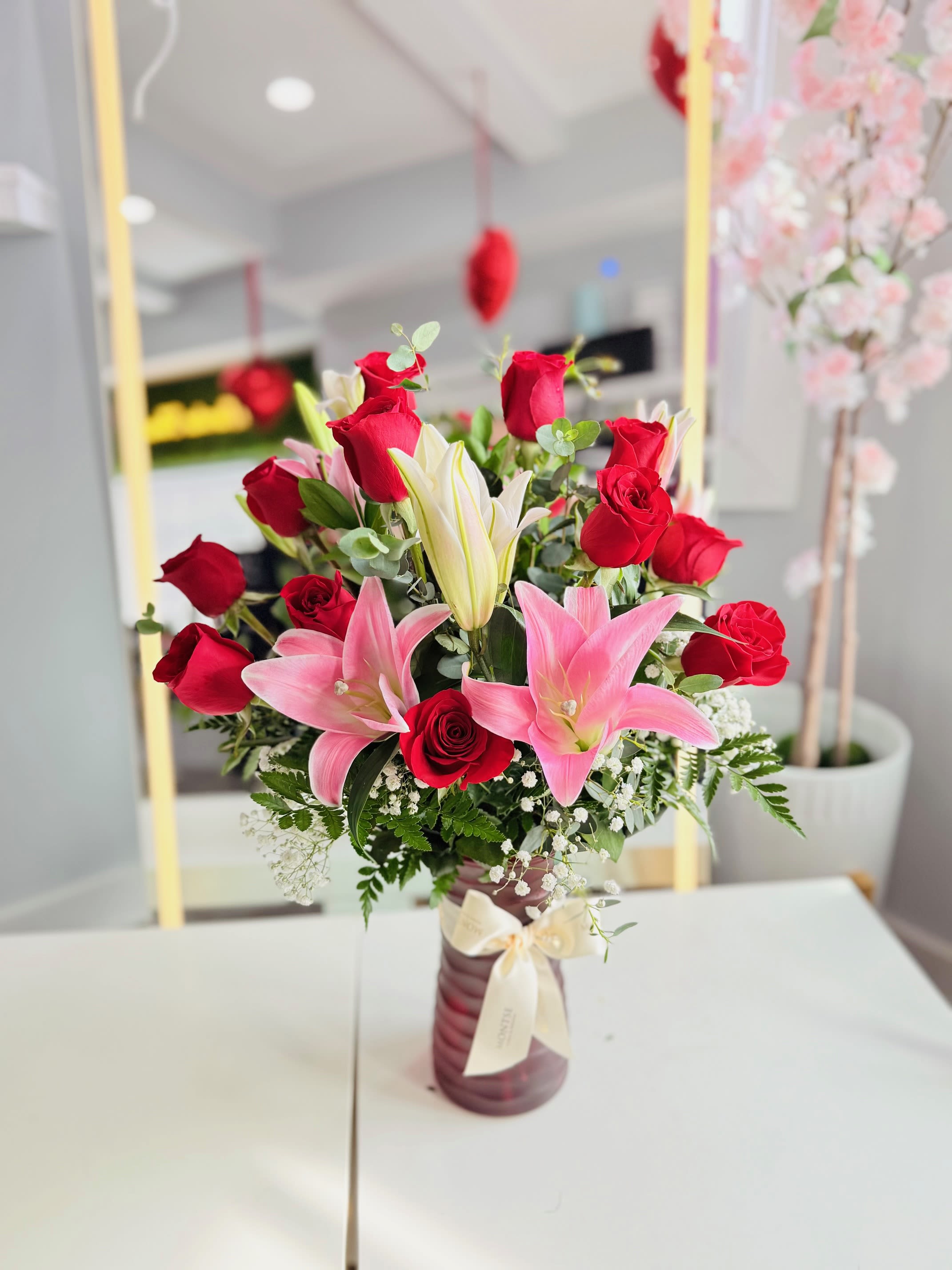 Bouquet of red roses and pink lilies in a vase