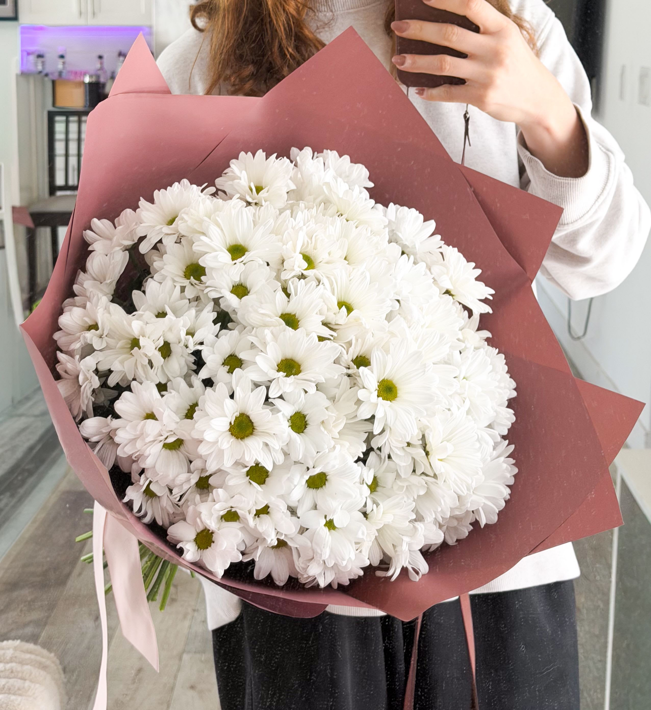 White Silence - A voluminous bouquet of fresh white chrysanthemums, arranged in a perfectly rounded dome for a soft, cloud-like effect. “White Silence” is about purity and simplicity — no distractions, just texture, shape, and balance. The crisp white petals paired with subtle green centers create a clean, modern look that feels both calming and elevated. Wrapped in muted tones to enhance its minimal aesthetic, this bouquet is timeless, versatile, and quietly striking. Perfect for elegant gestures, sympathy arrangements, or lovers of minimalist design.