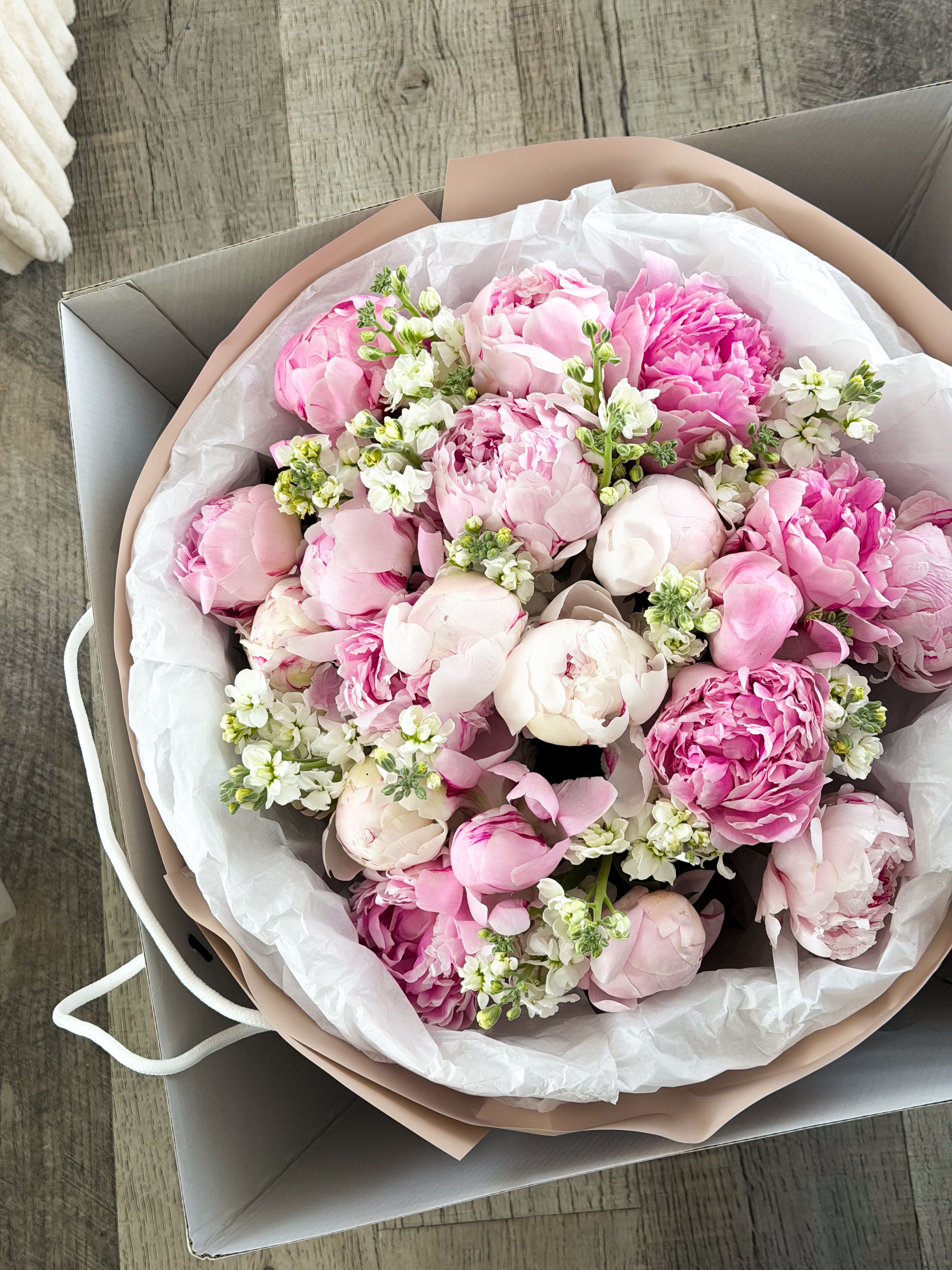 Soft Obsession - A lush, romantic bouquet centered around premium pink peonies, accented with delicate white florals for a soft, airy finish. “Soft Obsession” is all about texture and emotion — layers of ruffled petals in blush and rose tones create a full, cloud-like composition that feels both intimate and indulgent. Designed to feel effortless yet unforgettable, this bouquet captures that quiet intensity of something you can’t stop thinking about. Perfect for romantic gestures, anniversaries, or moments that need to feel deeply personal.