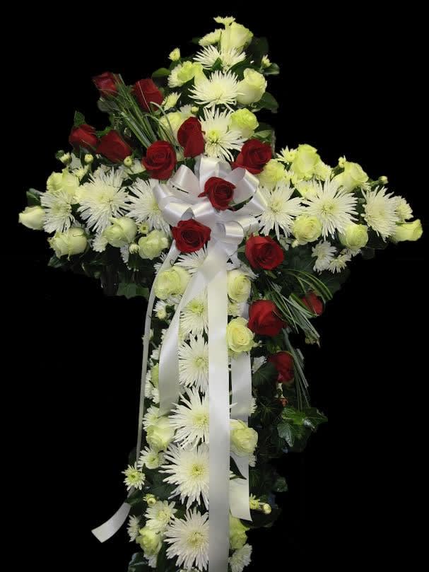 Cross-shaped floral spray with red roses, white chrysanthemums, and white ribbon