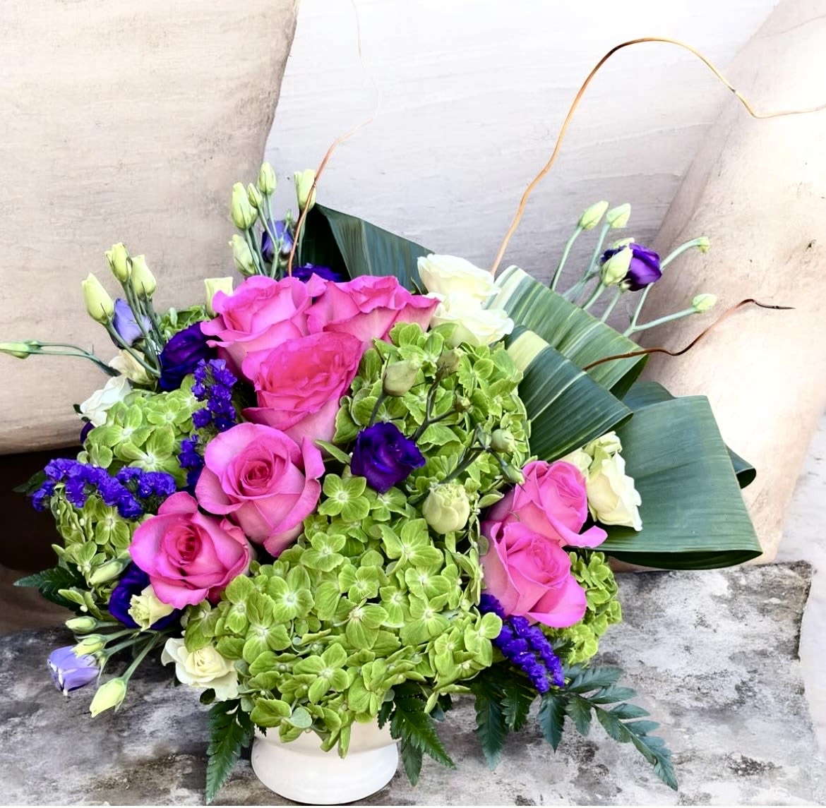 Elegant Embrace  - This beautifully designed arrangement has green hydrangea, roses, Lisianthus, aspidistra, spray roses, curly Willow and greenery.