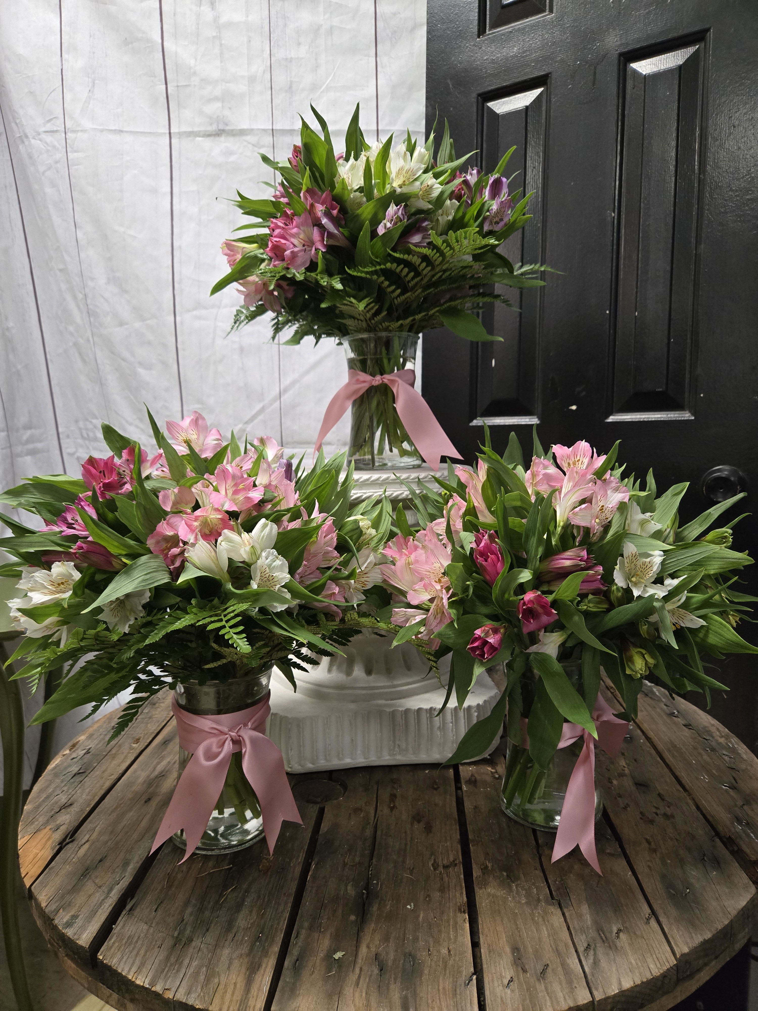 Awesome Astro - Three coordinated assorted colored alstroemeria arrangements with green foliage in glass vases, pink ribbons.
