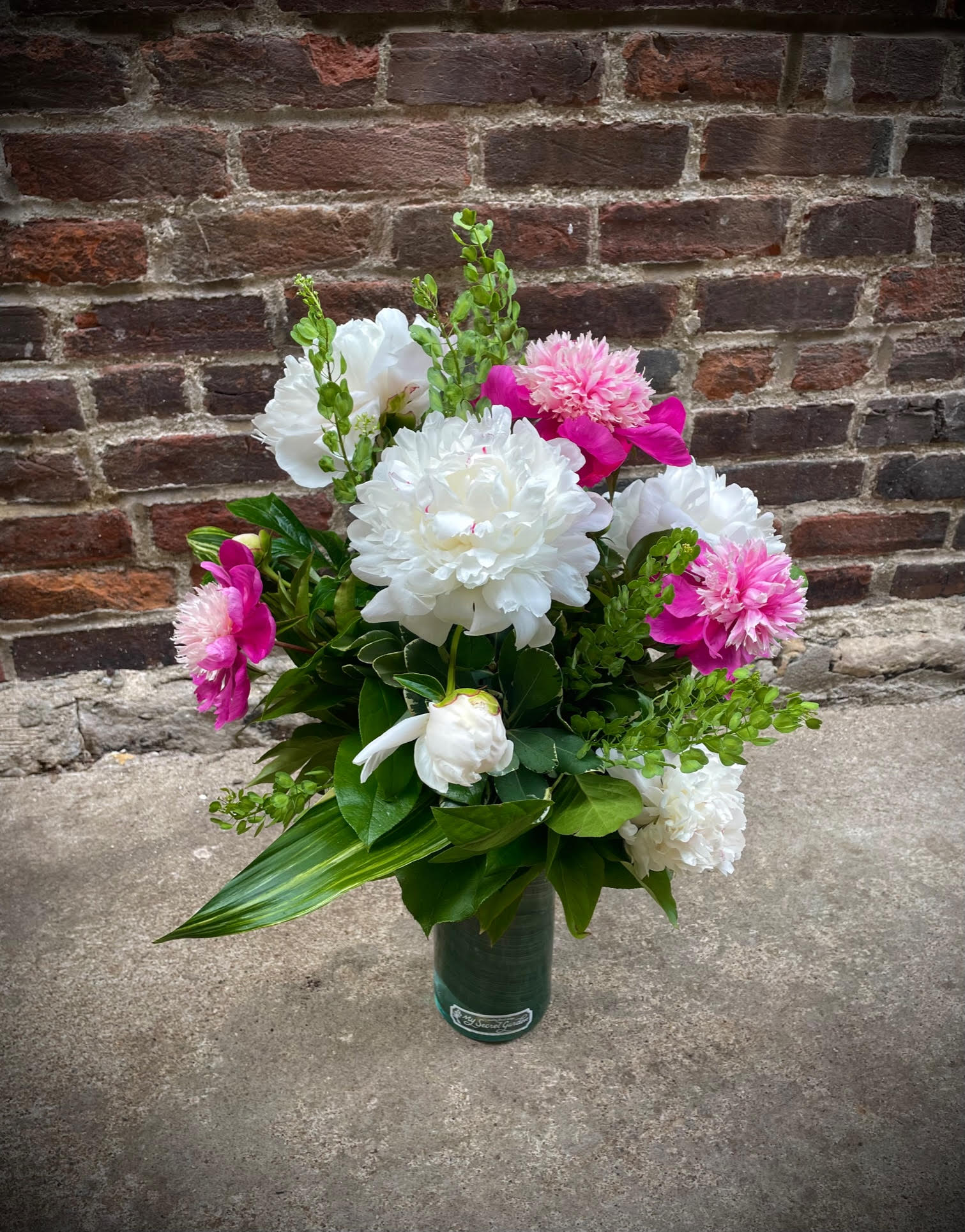 Bouquet of white and pink flowers in a green vase